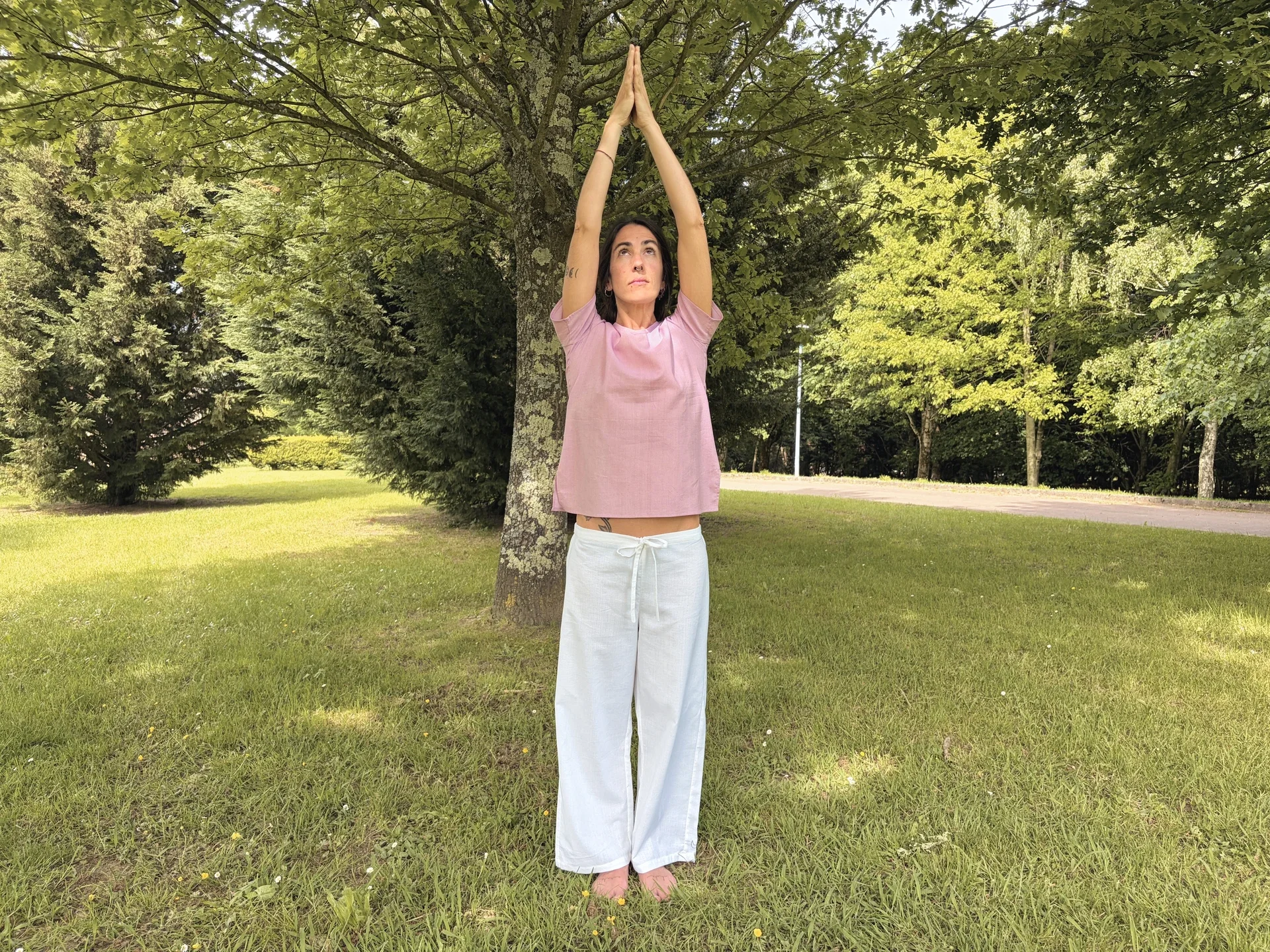 Mujer en postura de yoga vistiendo un pantalón ancho y fluido de algodón orgánico teñido con plantas naturales y hierbas medicinales ayurvastra