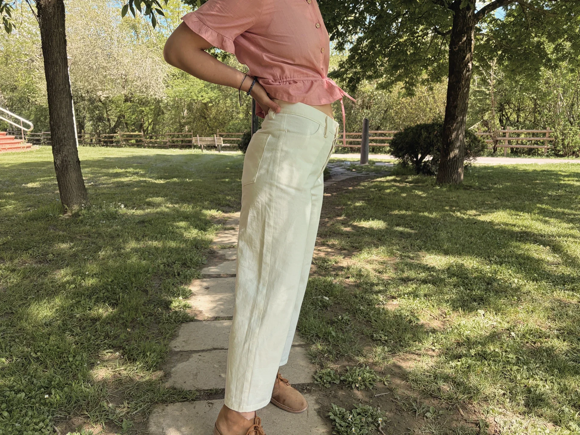 Mujer en la naturaleza vistiendo el Pantalón Luna de estilo denim. Pantalón de corte recto confeccionado en algodón orgánico natural con cierre de botones de coco. Moda consciente y sostenible.