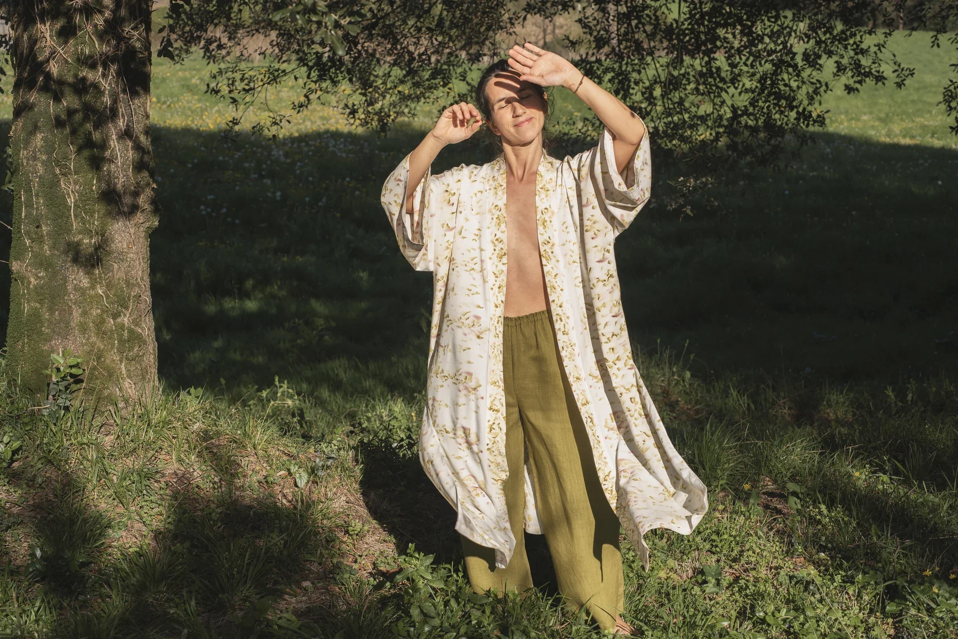 Mujer en la naturaleza vistiendo un kimono cruzado de fibra de loto con estampado botánico eco-print, medicina