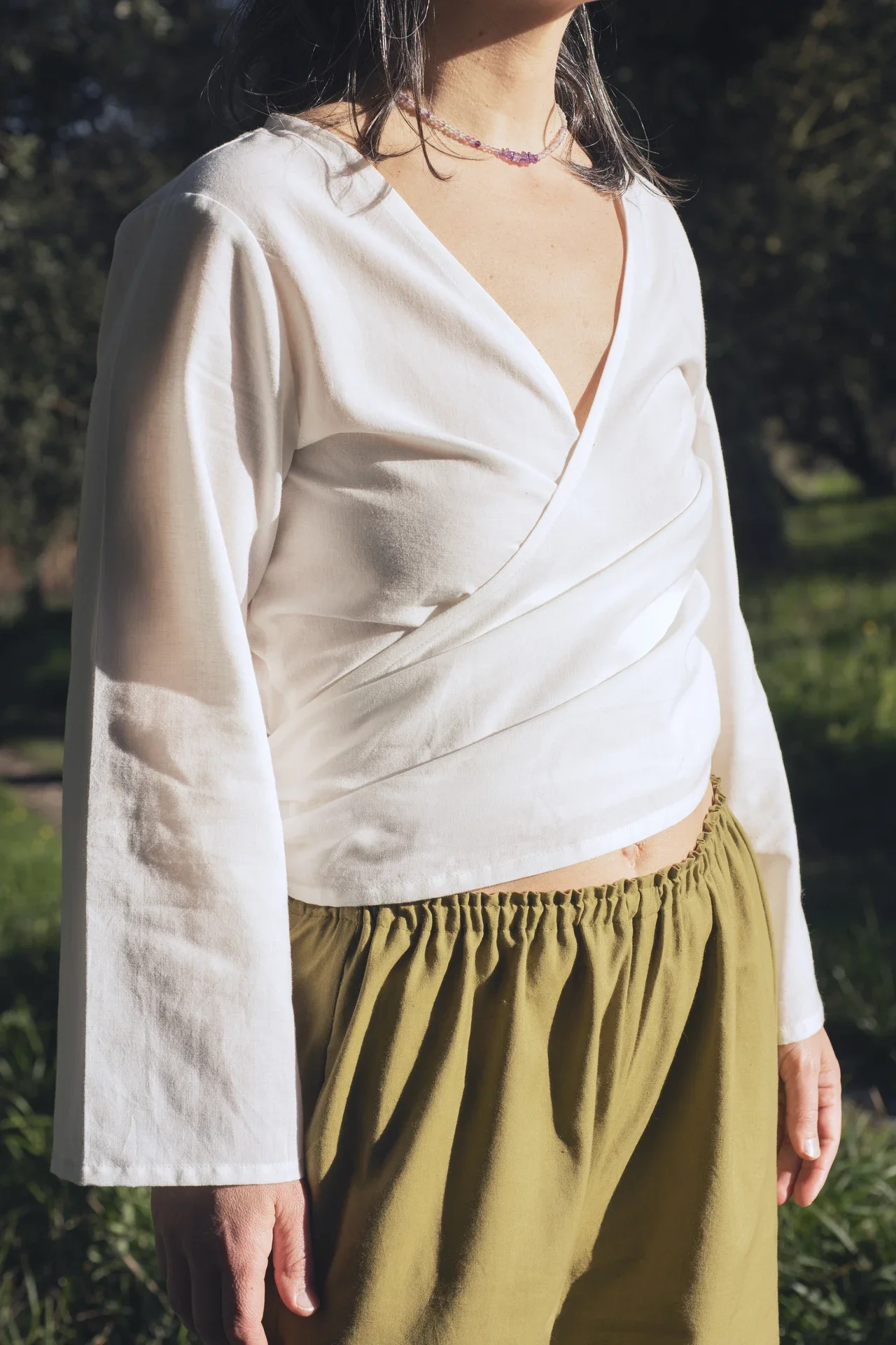 Mujer vistiendo la blusa cruzada Kali en algodón orgánico, teñida con tintes naturales