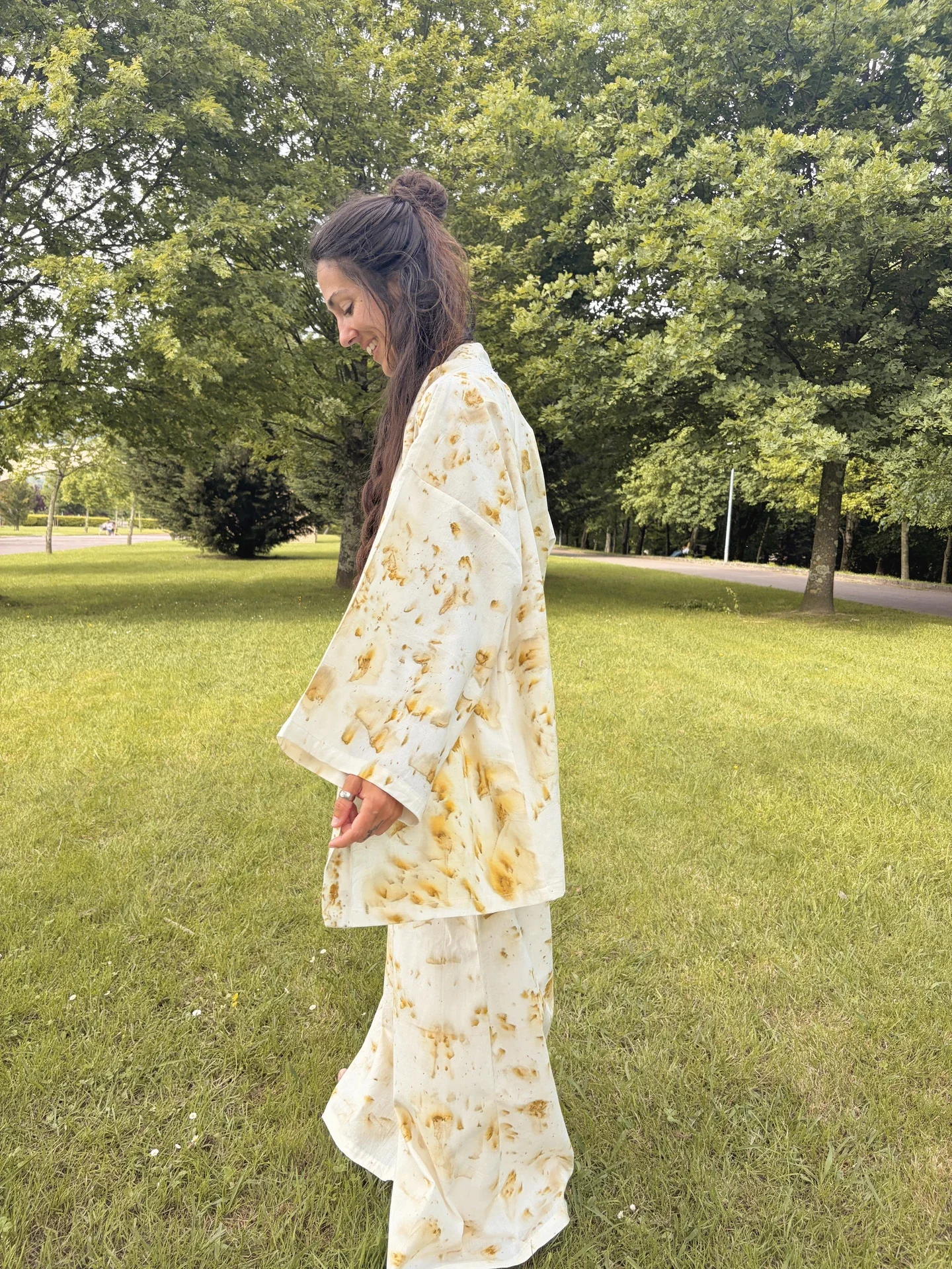 vistiendo un kimono de algodón orgánico claro con estampado botánico de flores doradas de Pericón