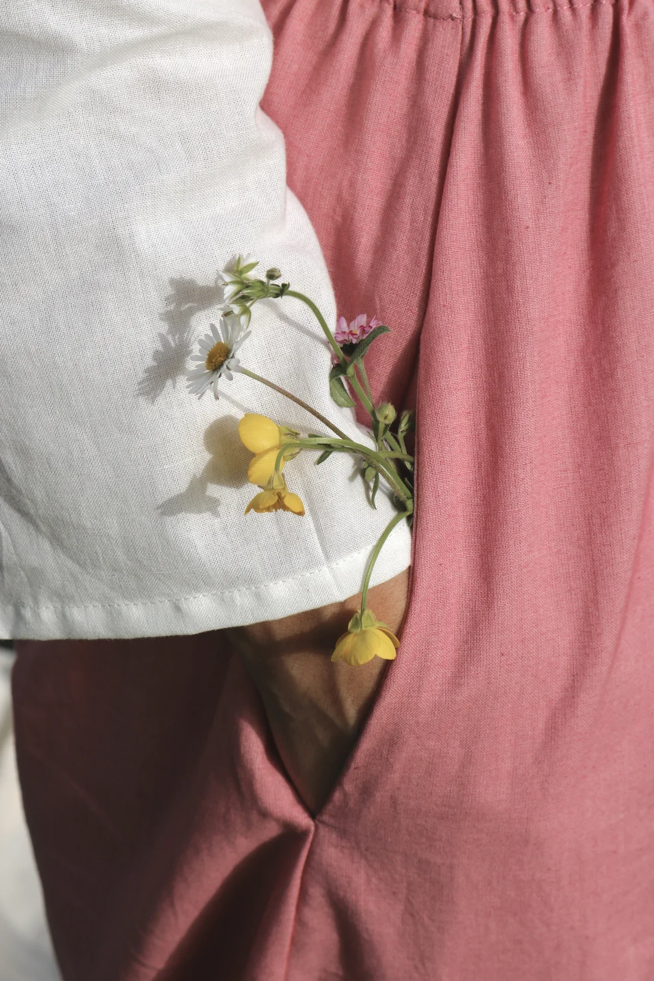 Mujer en la naturaleza vistiendo el Pantalón Orekan de pata ancha en color blanco, confeccionado en algodón orgánico y tintes naturales libres de tóxicos