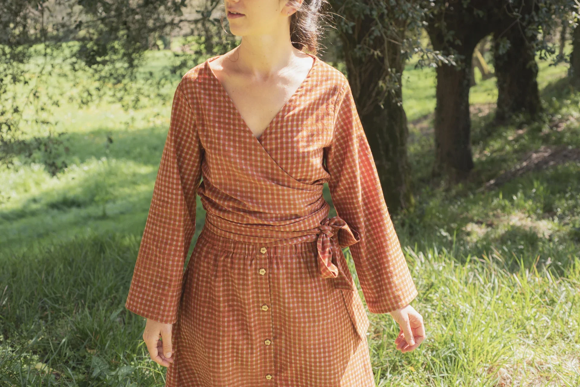 Mujer vistiendo blusa cruzada Kali de manga larga en algodón orgánico con estampado amanecer. Ropa teñida con tintes naturales sin tóxicos.