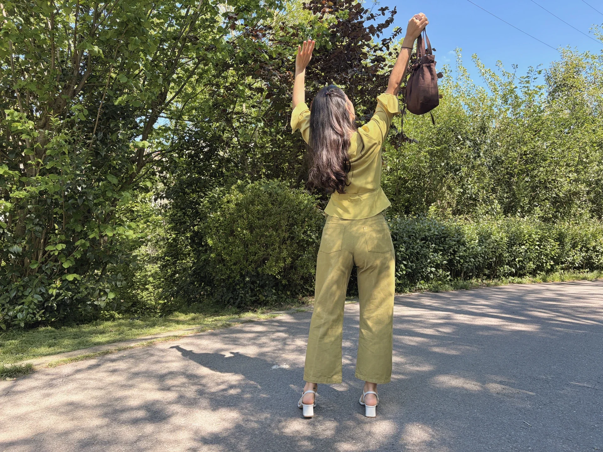 Mujer en la naturaleza vistiendo el Pantalón Luna de estilo denim. Pantalón de corte recto confeccionado en algodón orgánico natural con cierre de botones de coco. Moda consciente y sostenible.