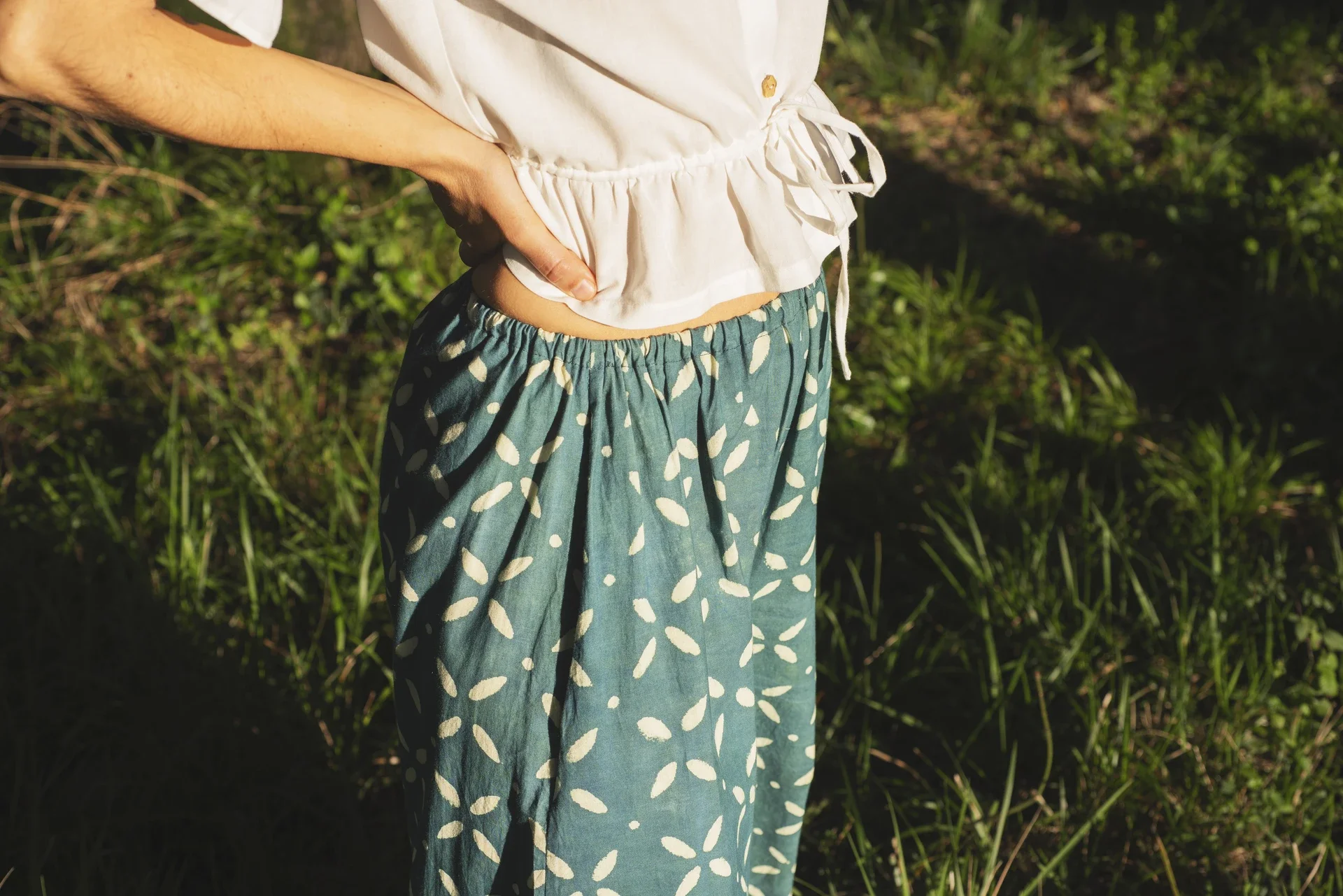 Mujer vistiendo un pantalón ancho de algodón orgánico color azul índigo con estampado a mano en un entorno natural.