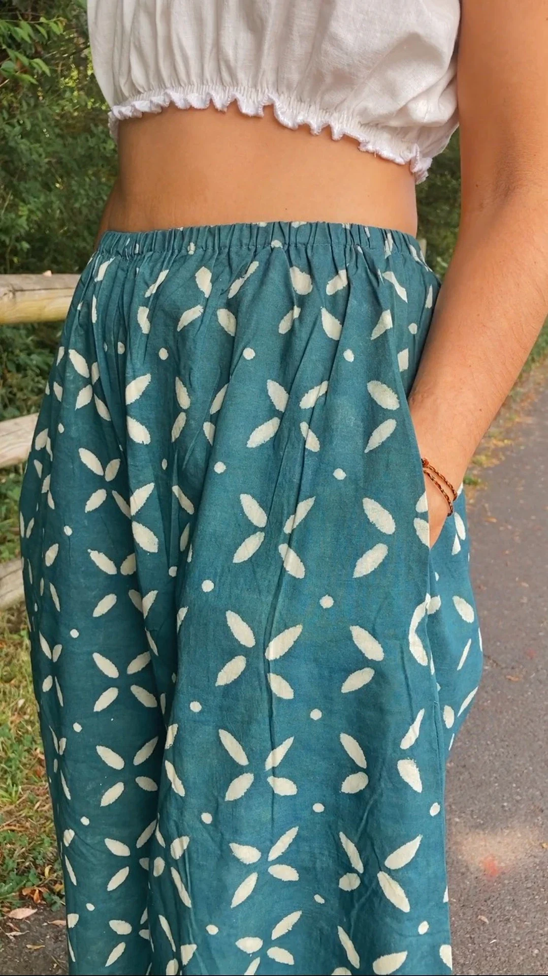 Mujer vistiendo un pantalón ancho de algodón orgánico color azul índigo con estampado a mano en un entorno natural.