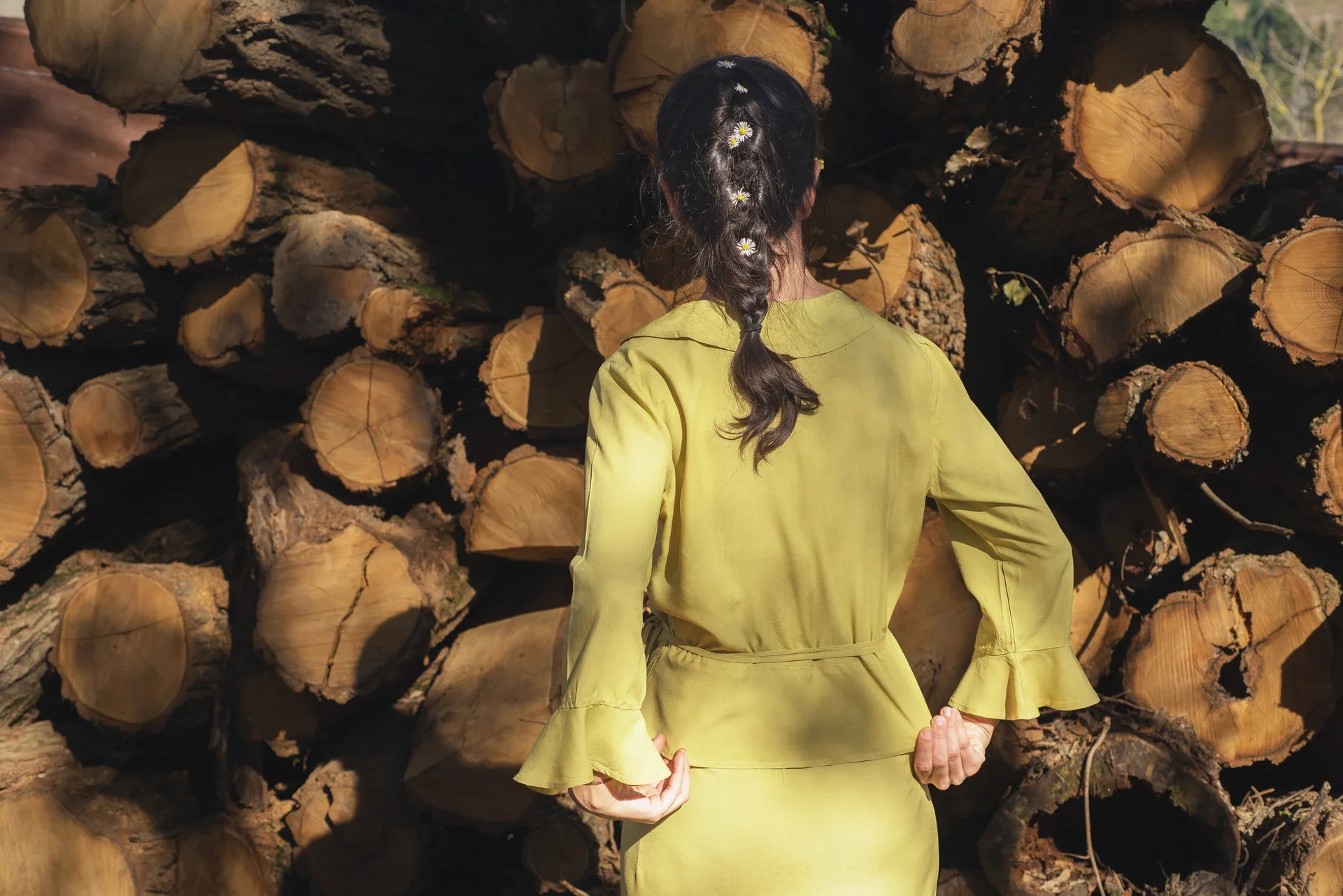 Mujer vistiendo la Blusa Agni cruzada de color verde pistacho, confeccionada en fibra de loto natural con detalles de volantes en las mangas