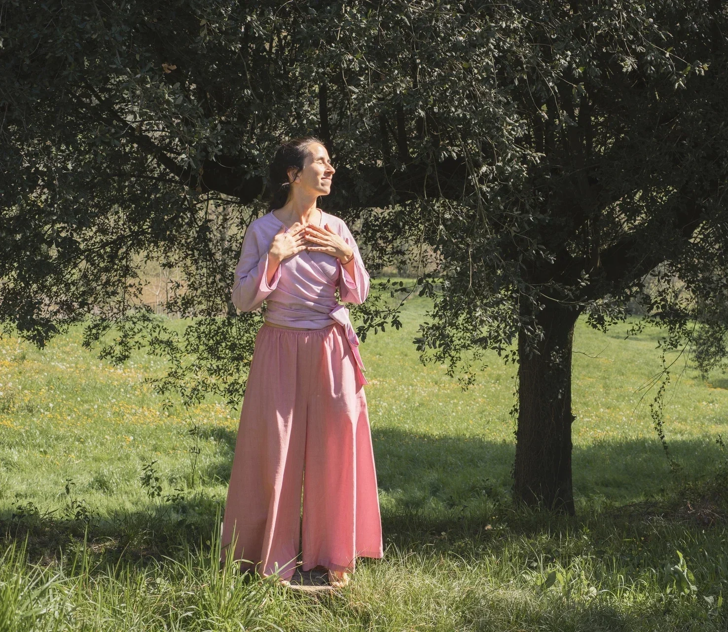 Mujer en la naturaleza vistiendo el Pantalón Orekan de pata ancha en color blanco, confeccionado en algodón orgánico y tintes naturales libres de tóxicos