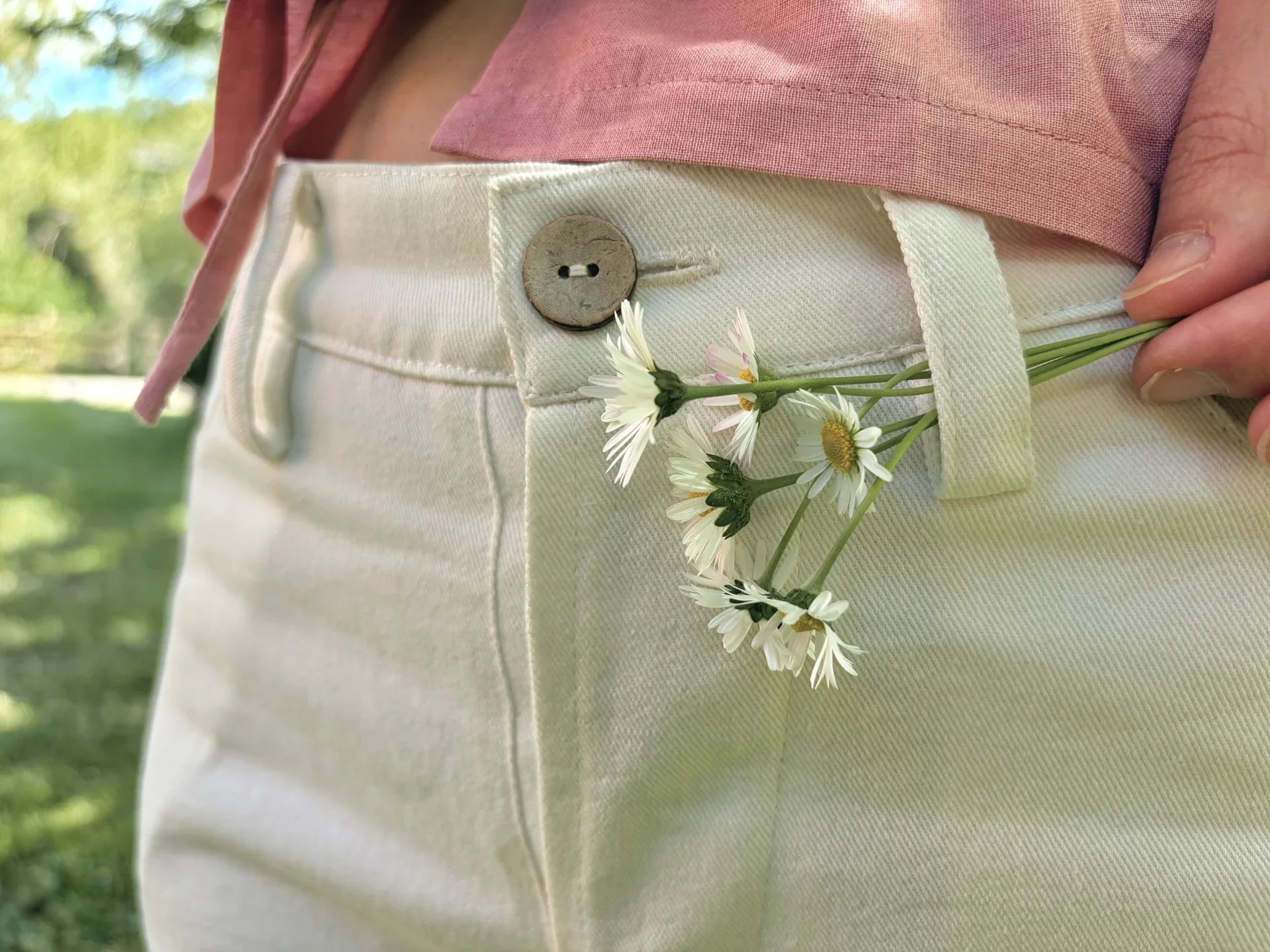 Mujer en la naturaleza vistiendo el Pantalón Luna de estilo denim. Pantalón de corte recto confeccionado en algodón orgánico natural con cierre de botones de coco. Moda consciente y sostenible.