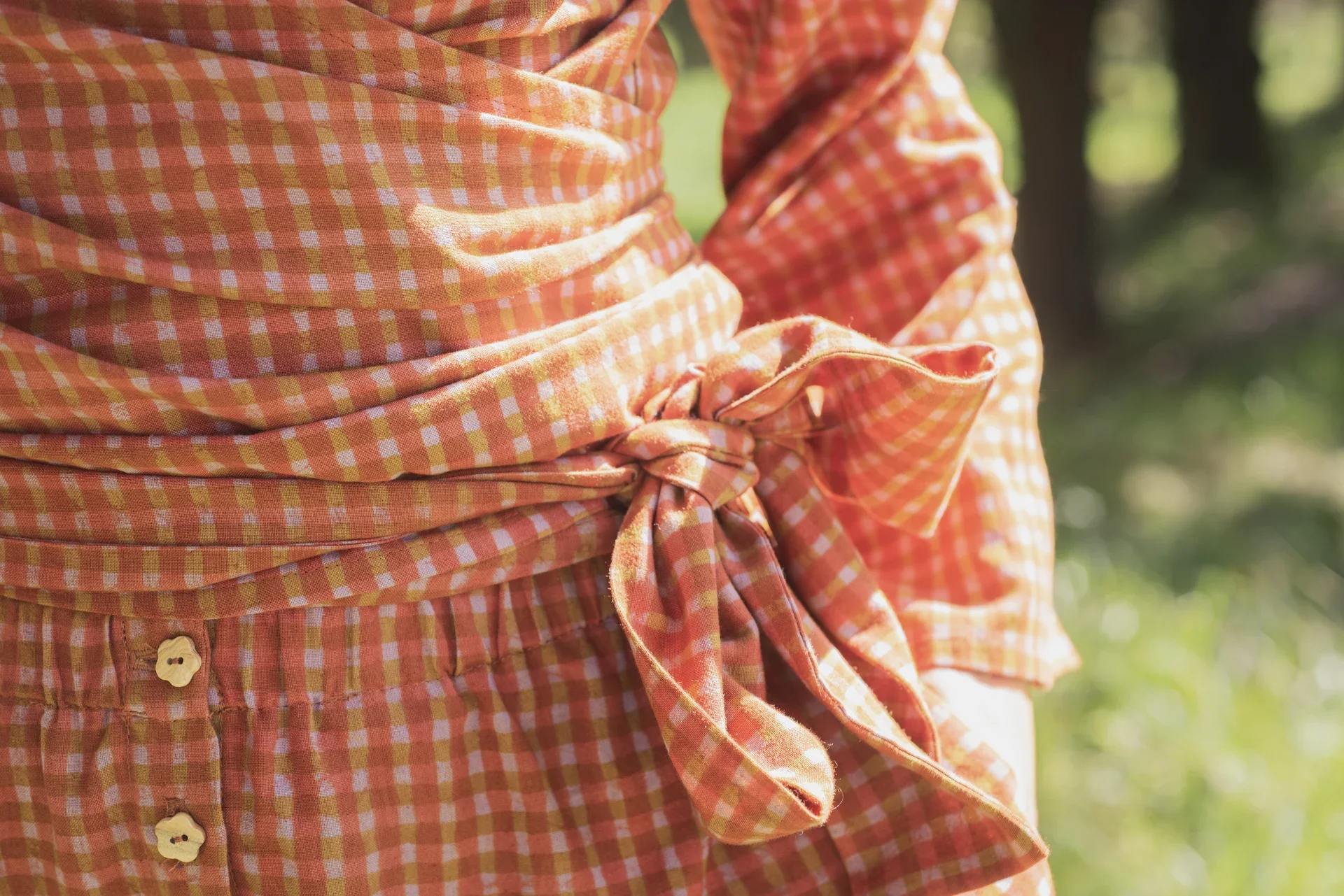 Mujer vistiendo blusa cruzada Kali de manga larga en algodón orgánico con estampado amanecer. Ropa teñida con tintes naturales sin tóxicos.