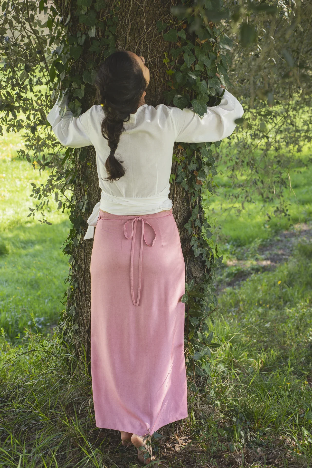 Mujer en un entorno natural vistiendo una falda envolvente estilo pareo color mostaza confeccionada en fibra de loto y teñida con tintes naturales