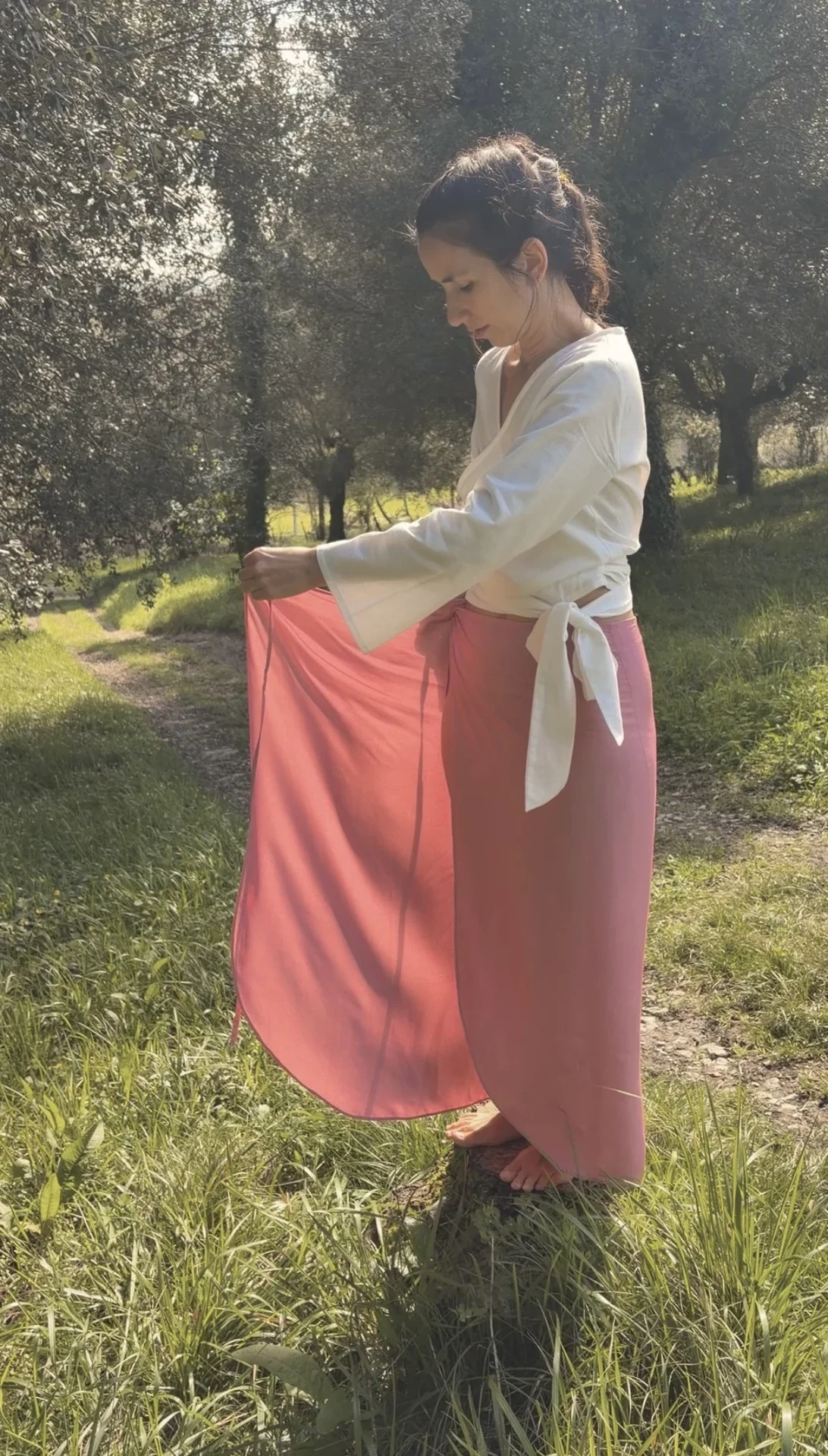 Mujer en un entorno natural vistiendo una falda envolvente estilo pareo color mostaza confeccionada en fibra de loto y teñida con tintes naturales
