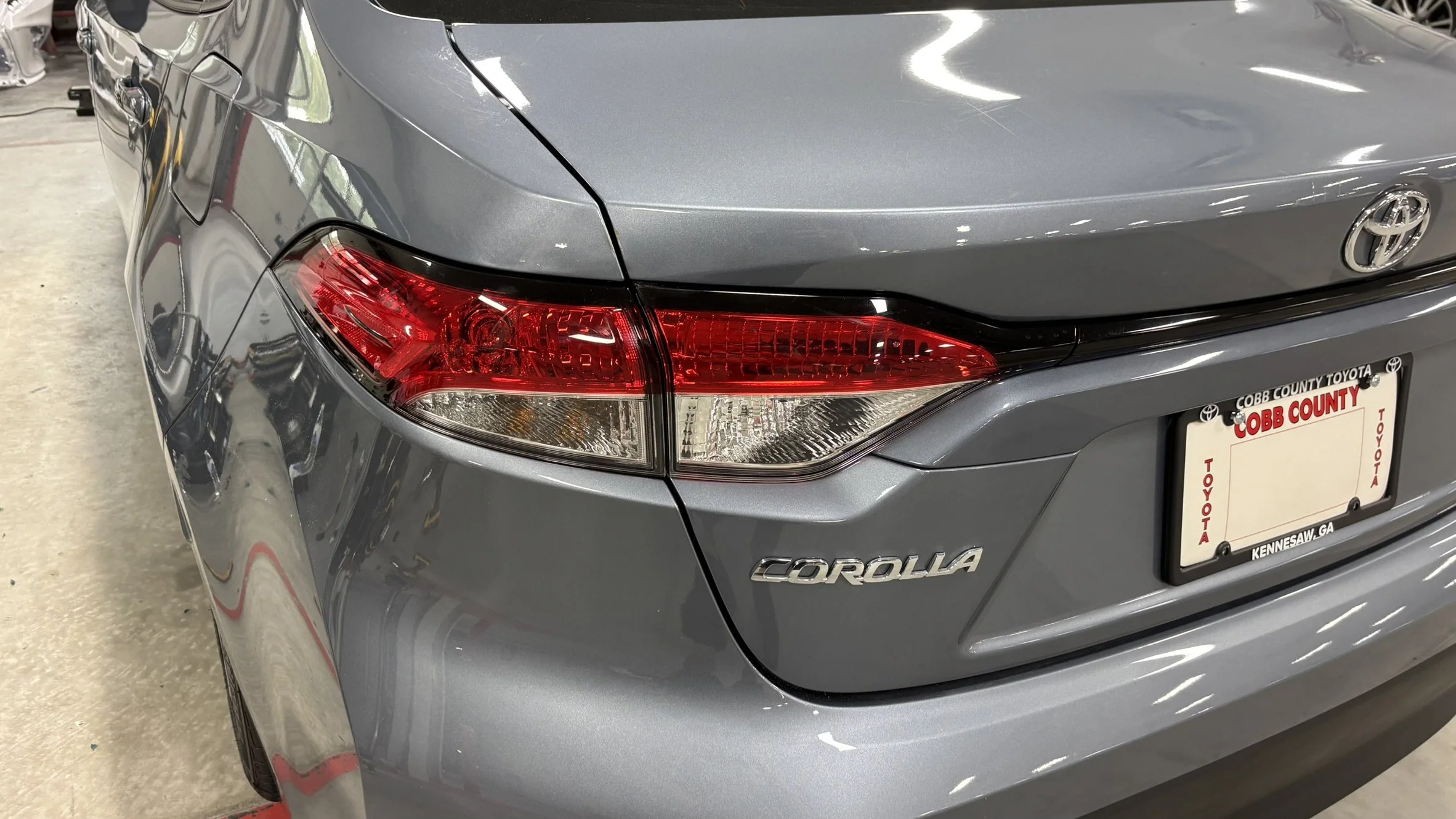 The rear of a gray Toyota Corolla showing the taillight, badge, and a license plate from Cobb County, Georgia.