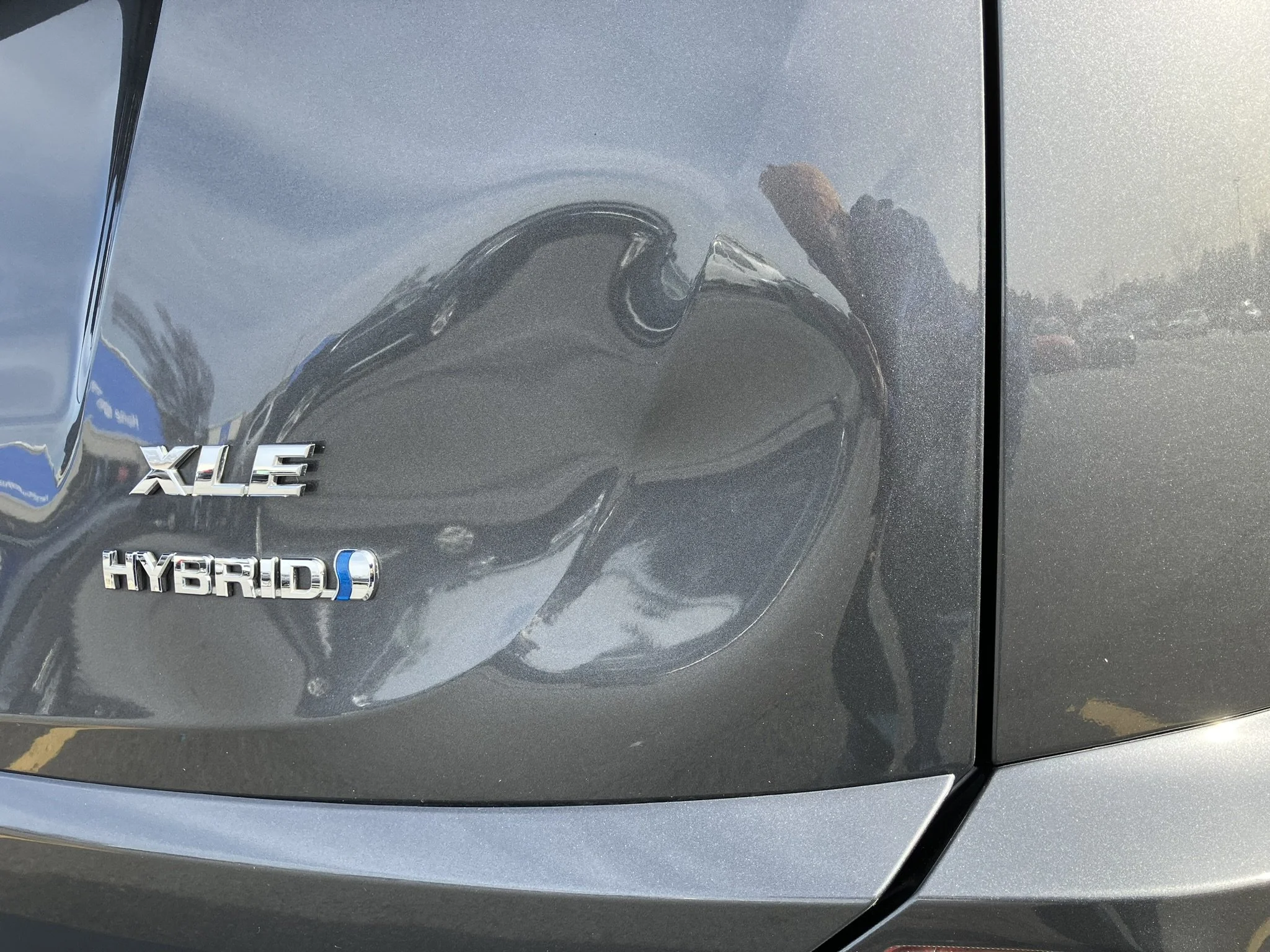 The rear end of a gray Hyundai vehicle with badges reading 'XLE' and 'HYBRID'.