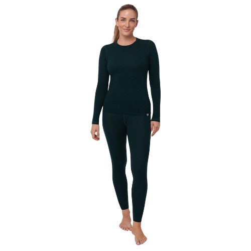 A woman standing barefoot, wearing a dark teal long-sleeve athletic top and matching leggings, smiling at the camera.