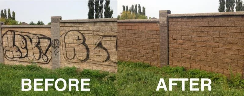 Graffiti removal service showing black spray paint being successfully cleaned off a stone block wall without damaging the masonry.