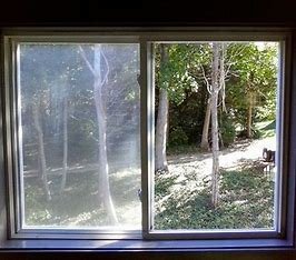 Before and after of a residential window, showing the removal of hard water stains and dirt for a streak-free, clear view.