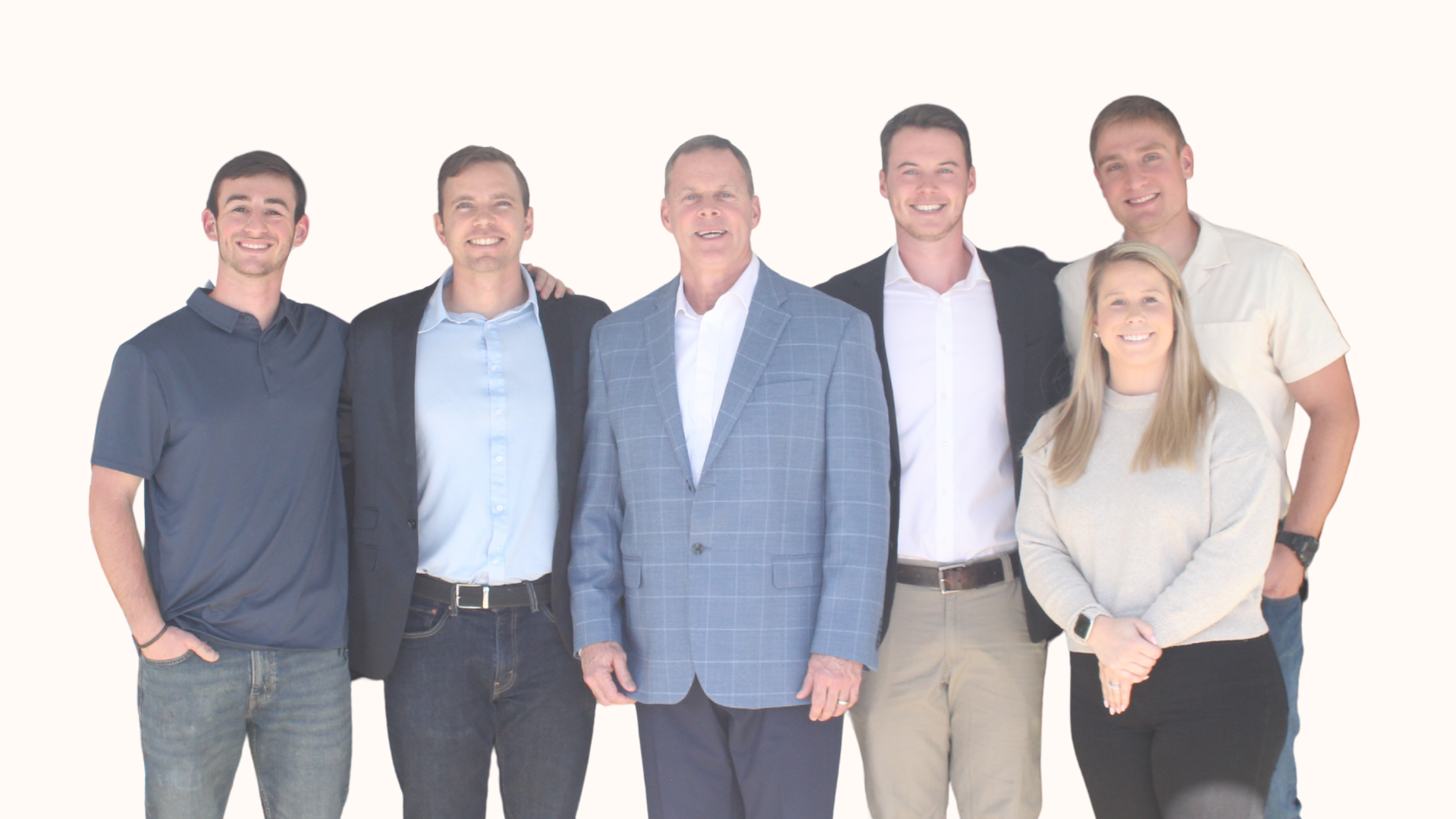 Group of six people, five men and one woman, standing together against a white background, smiling for the photo.