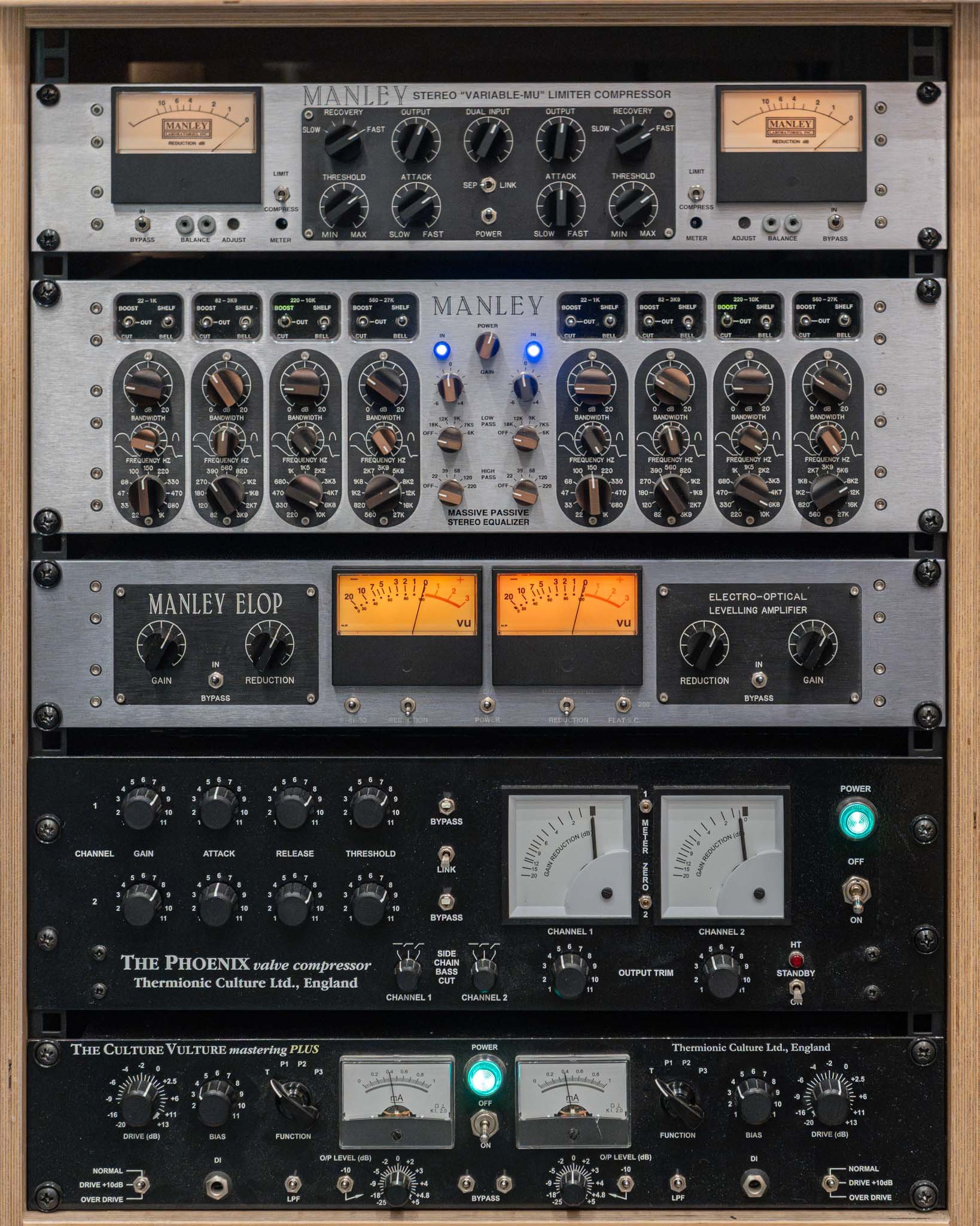 A collection of professional audio equipment including compressors, equalizers, and amplifiers arranged in a rack.