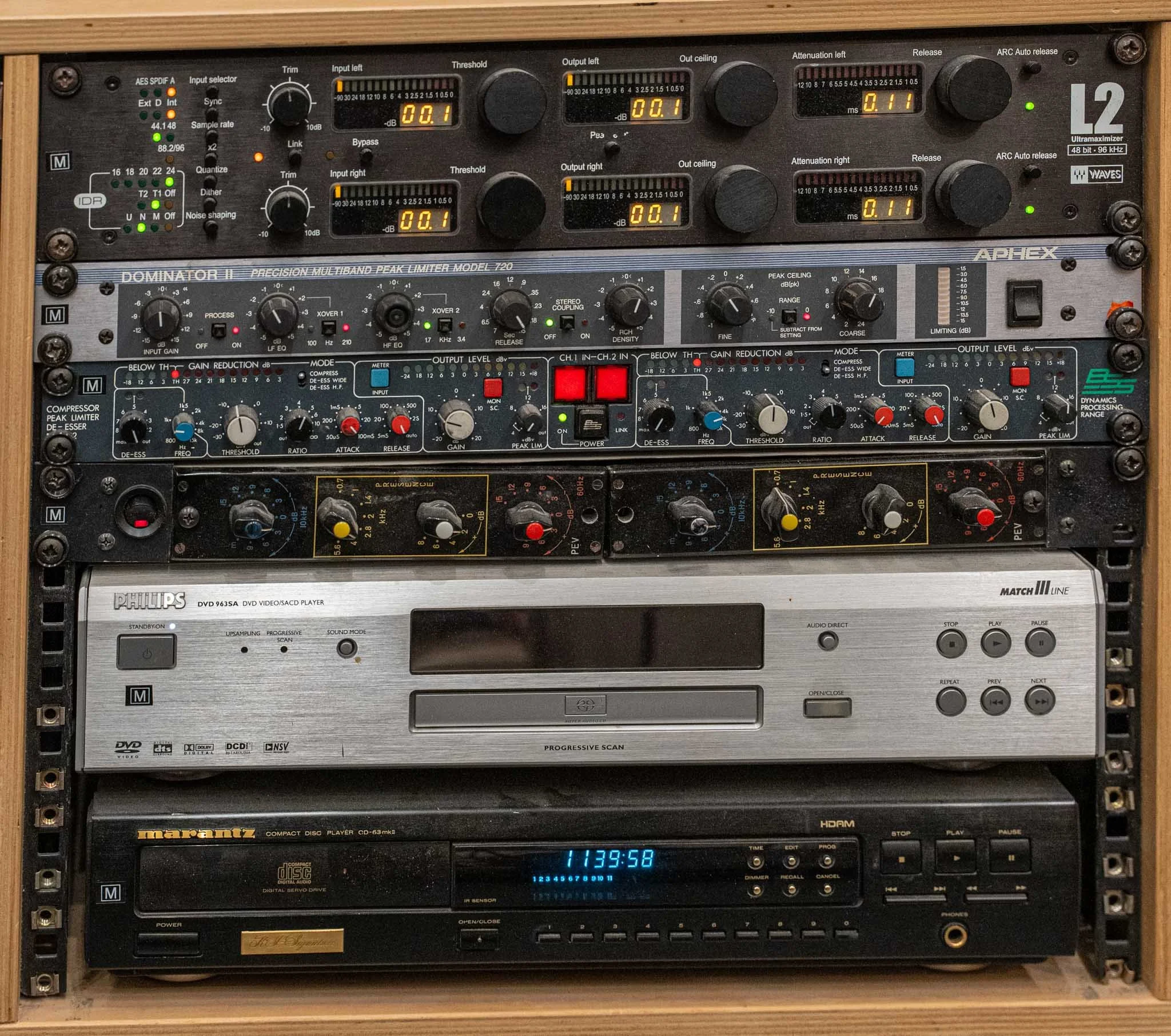 Audio equipment rack with a DJ mixer, audio processor, DVD player, and CD player.