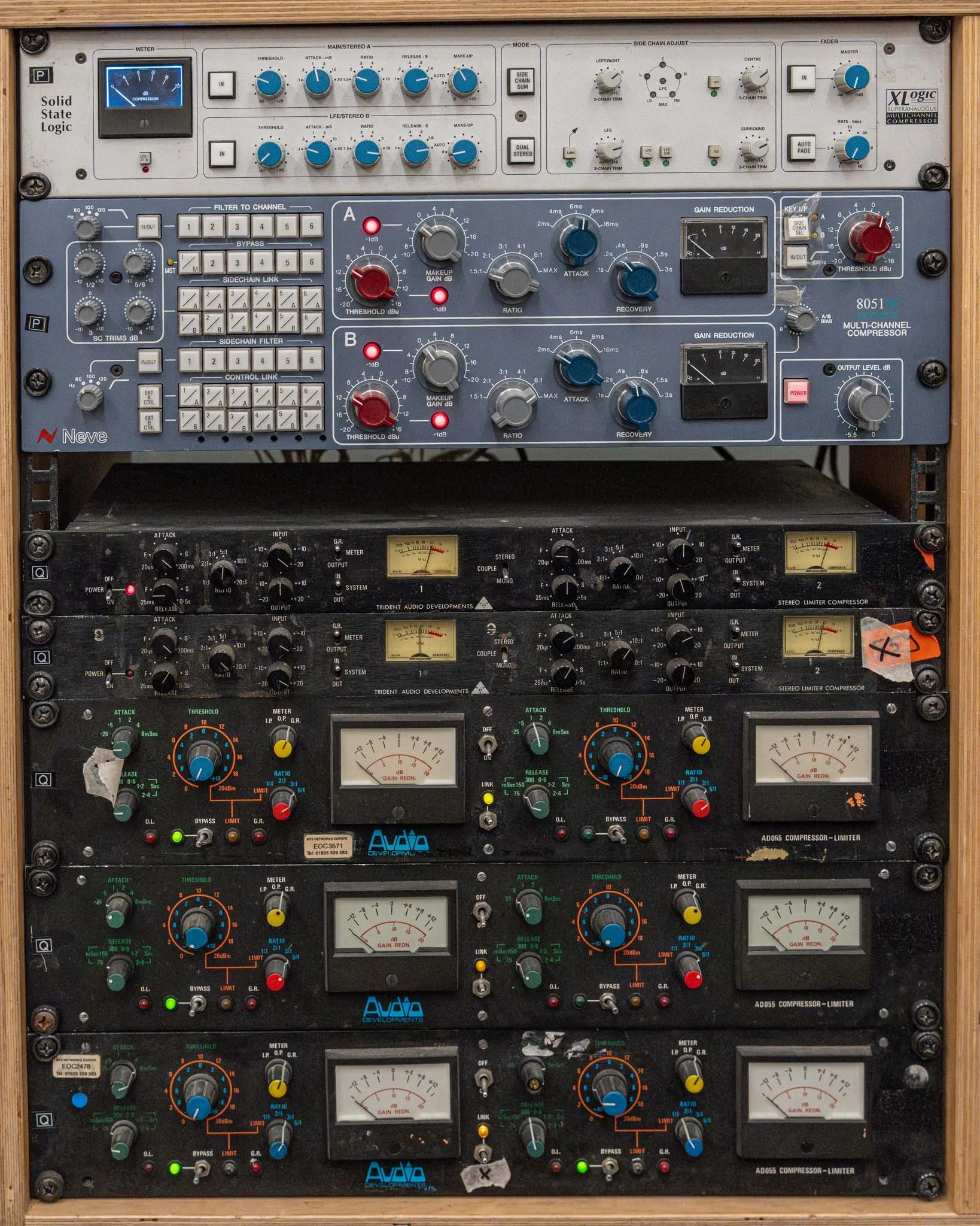 A rack-mounted audio equipment setup with various mixers, compressors, and limiters.