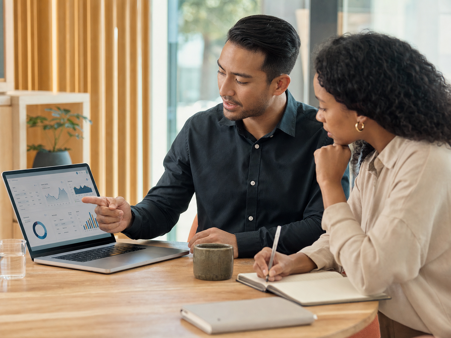 Business partners reviewing qualified lead performance and campaign routing on a laptop.