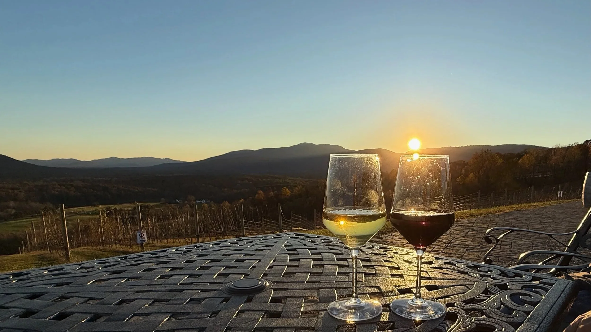 Wine glasses at sunset overlooking the Blue Ridge Mountains at Hazy Mountain Vineyard near Wintergreen, Virginia.