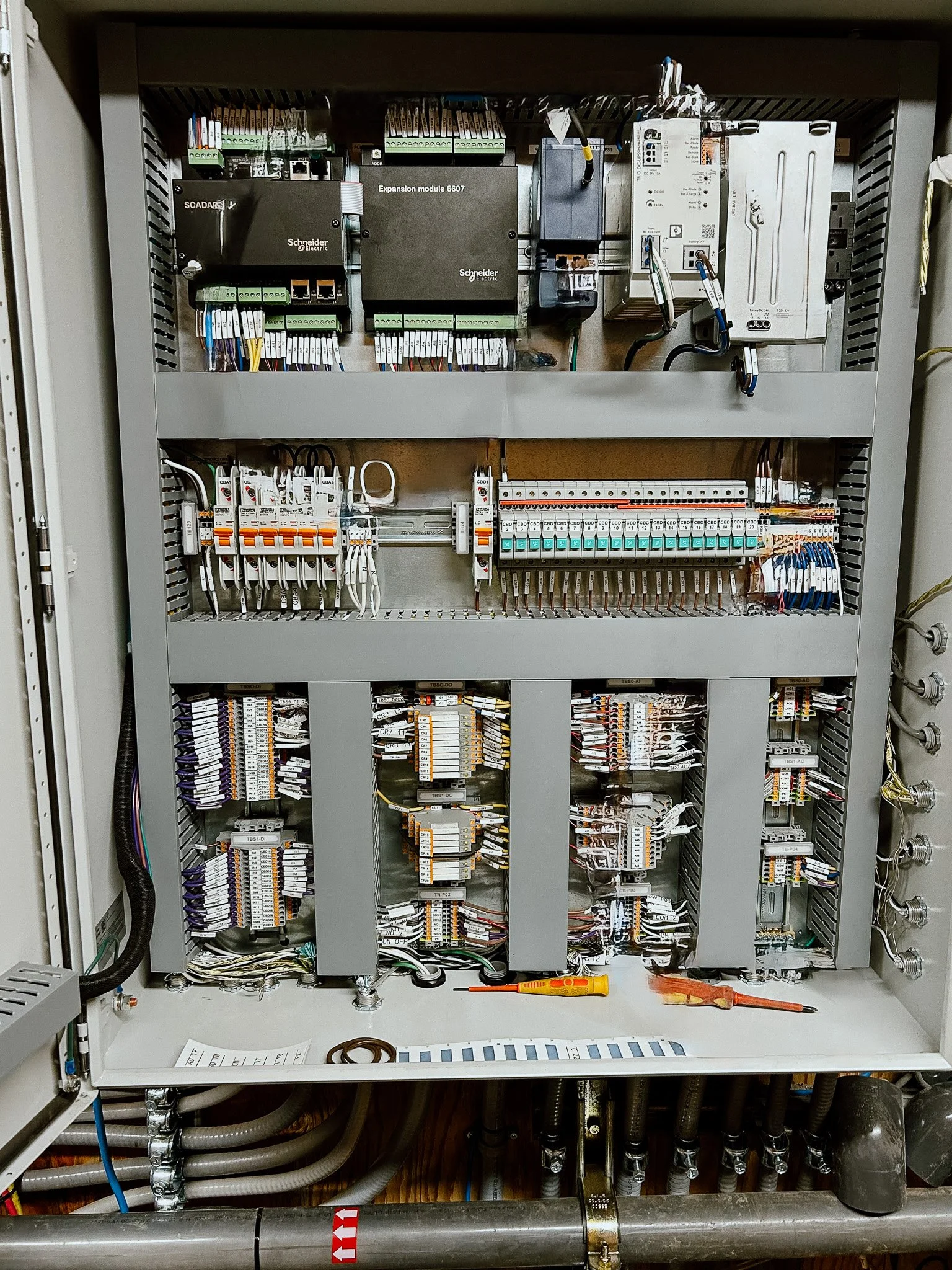 Electrical control panel with circuit breakers, relays, and wiring for industrial or building automation.