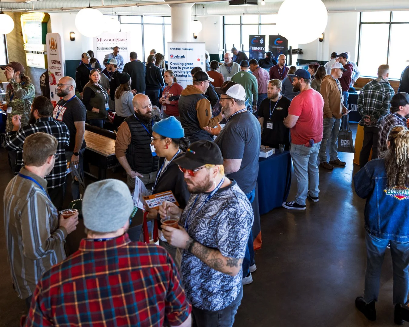 several conference attendees walk around the trade show area visiting with vendors