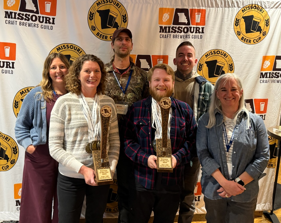 representatives from the two breweries of the year pose with their trophies and the executive director of the guild