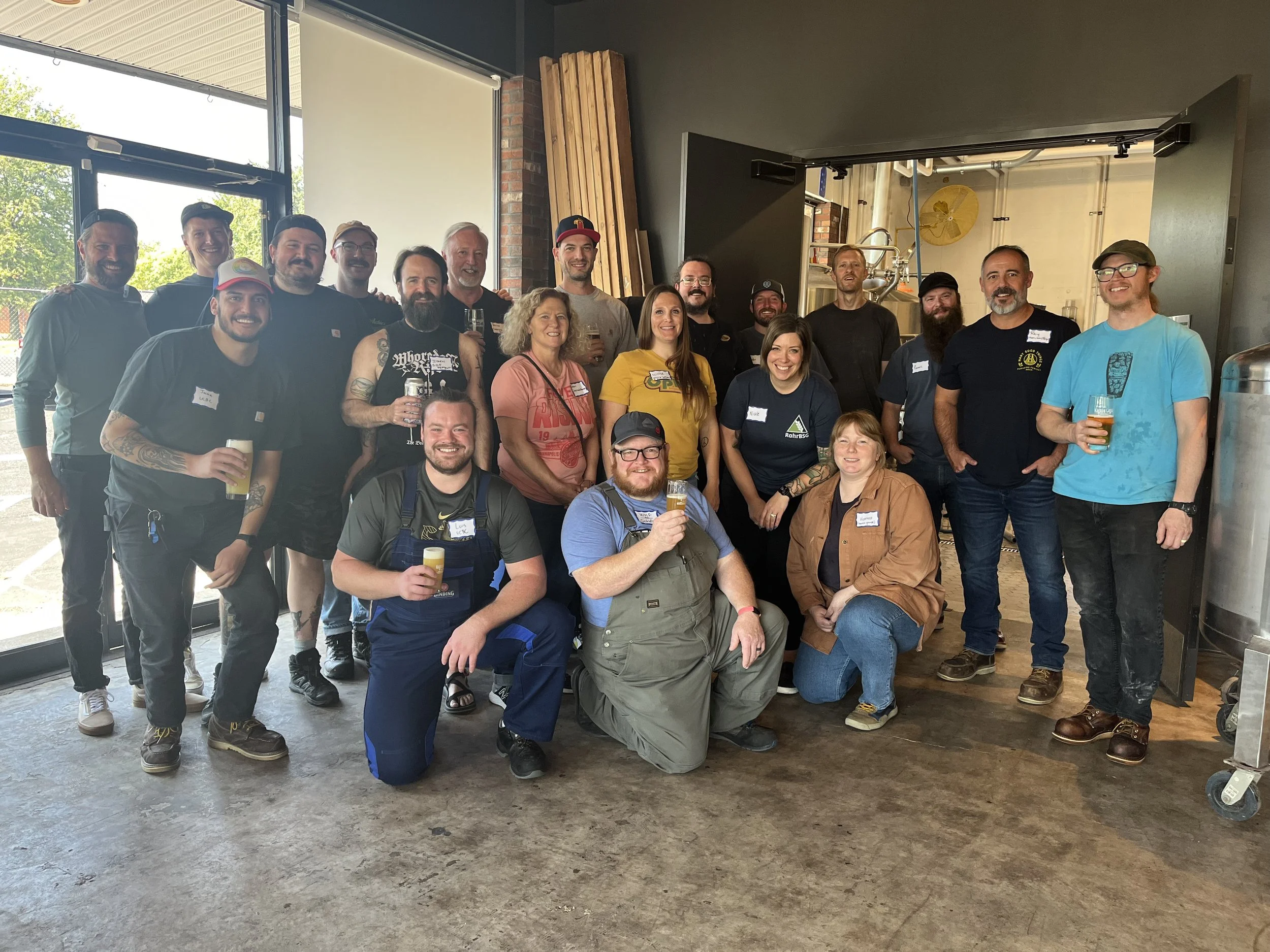 group of women and men posing at a brewery after working together to make a new craft beer
