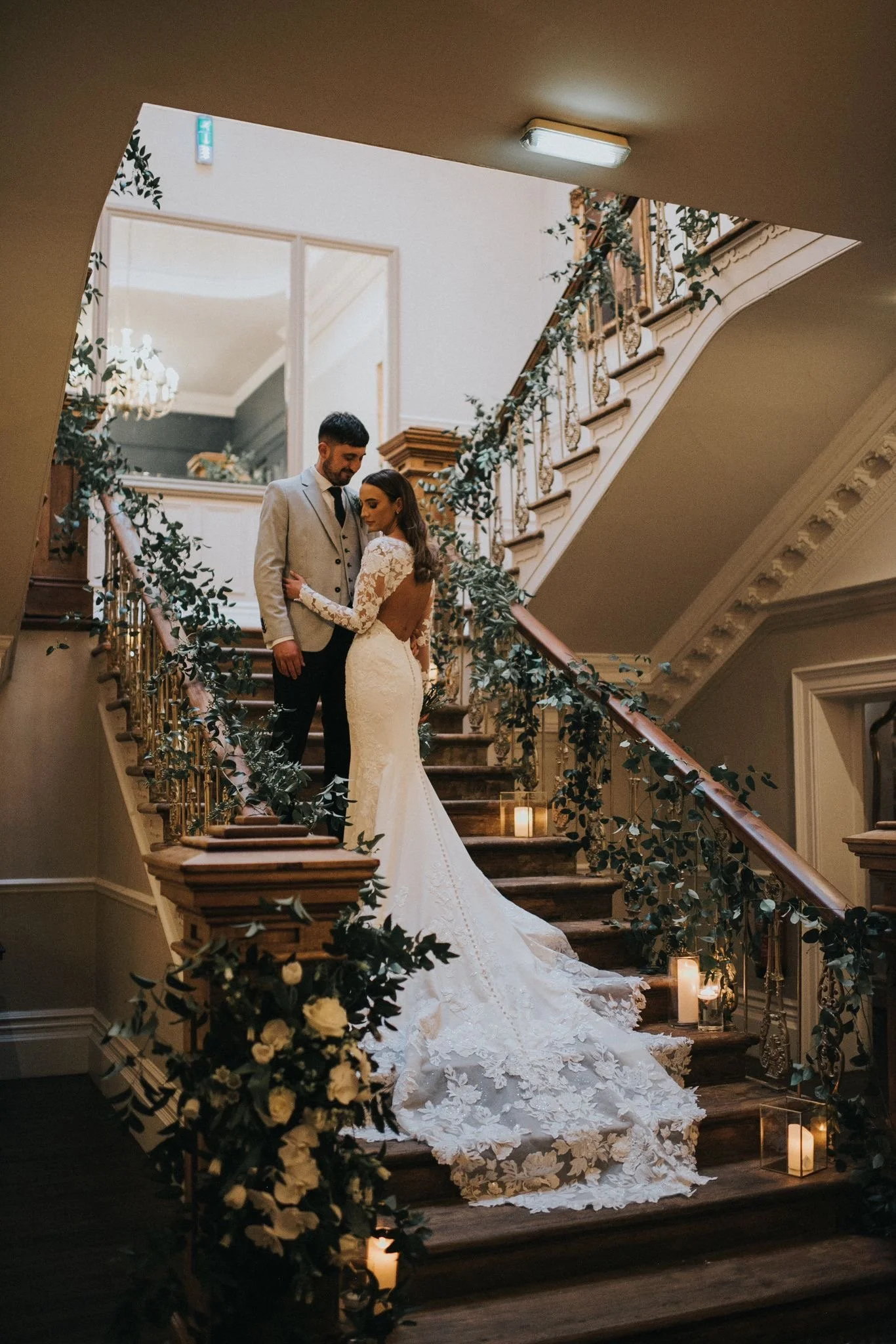 Peacock & Wild Floristry and Education (formerly The Blossom Room) Bride and Groom on a staircase at Ashfield House Wigan with flowers and vines wedding decor