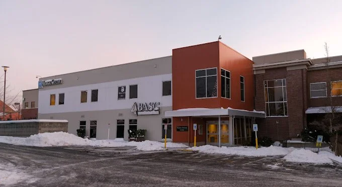 Exterior of a two-story hospital building with snow on the ground, featuring BASC signage on the front.