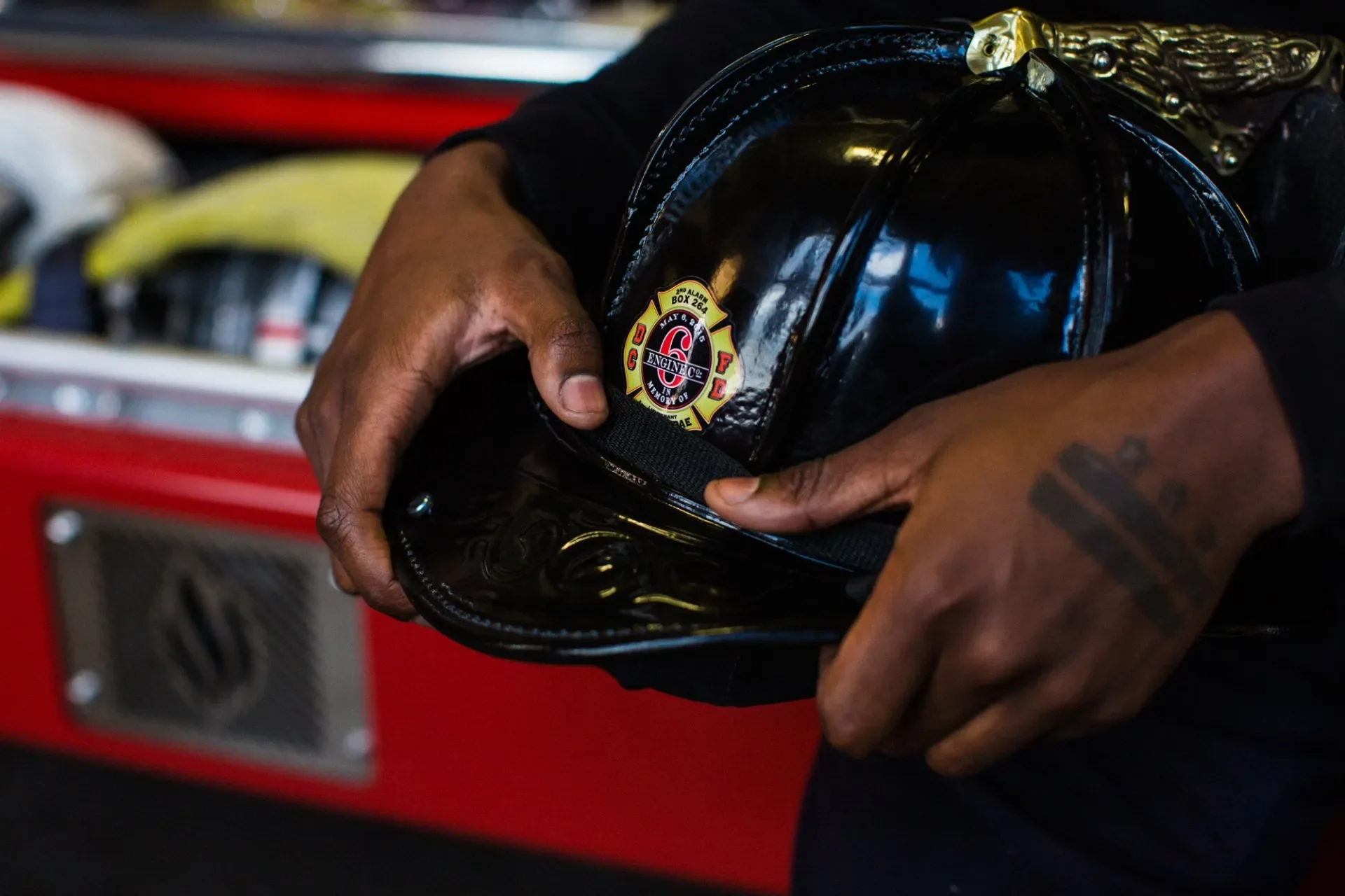 Da'Von holds his fire helmet with a decal in remembrance of his father, Lt. Kevin McRae, and the incident that took place on May 6, 2015. Photograph by Erica Baker