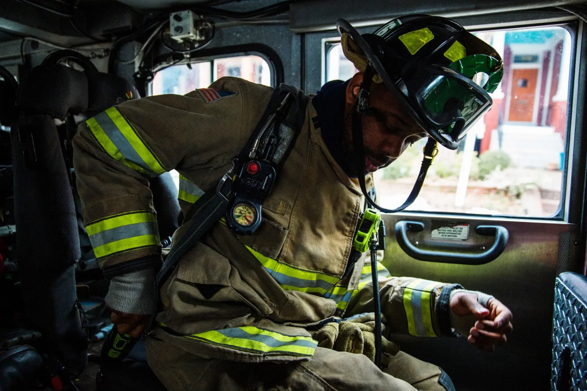 Jonathan Tate checks his radio as his truck company responds to a fire call. Photograph by Erica Baker