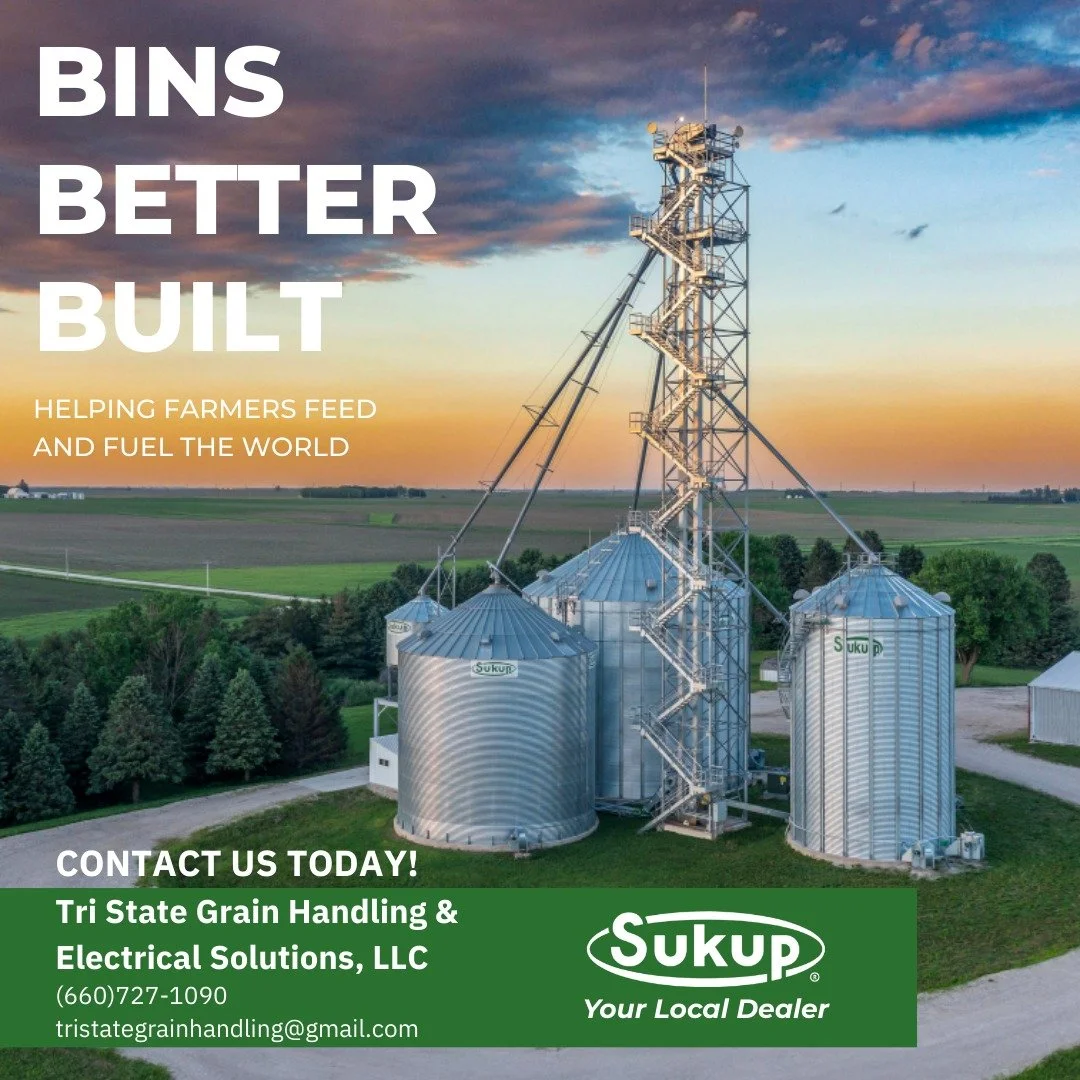 A grain handling facility with storage silos and a tall steel structure against a sunset sky. The image includes text promoting grain bin construction and electrical solutions by Sukup, a local dealer.
