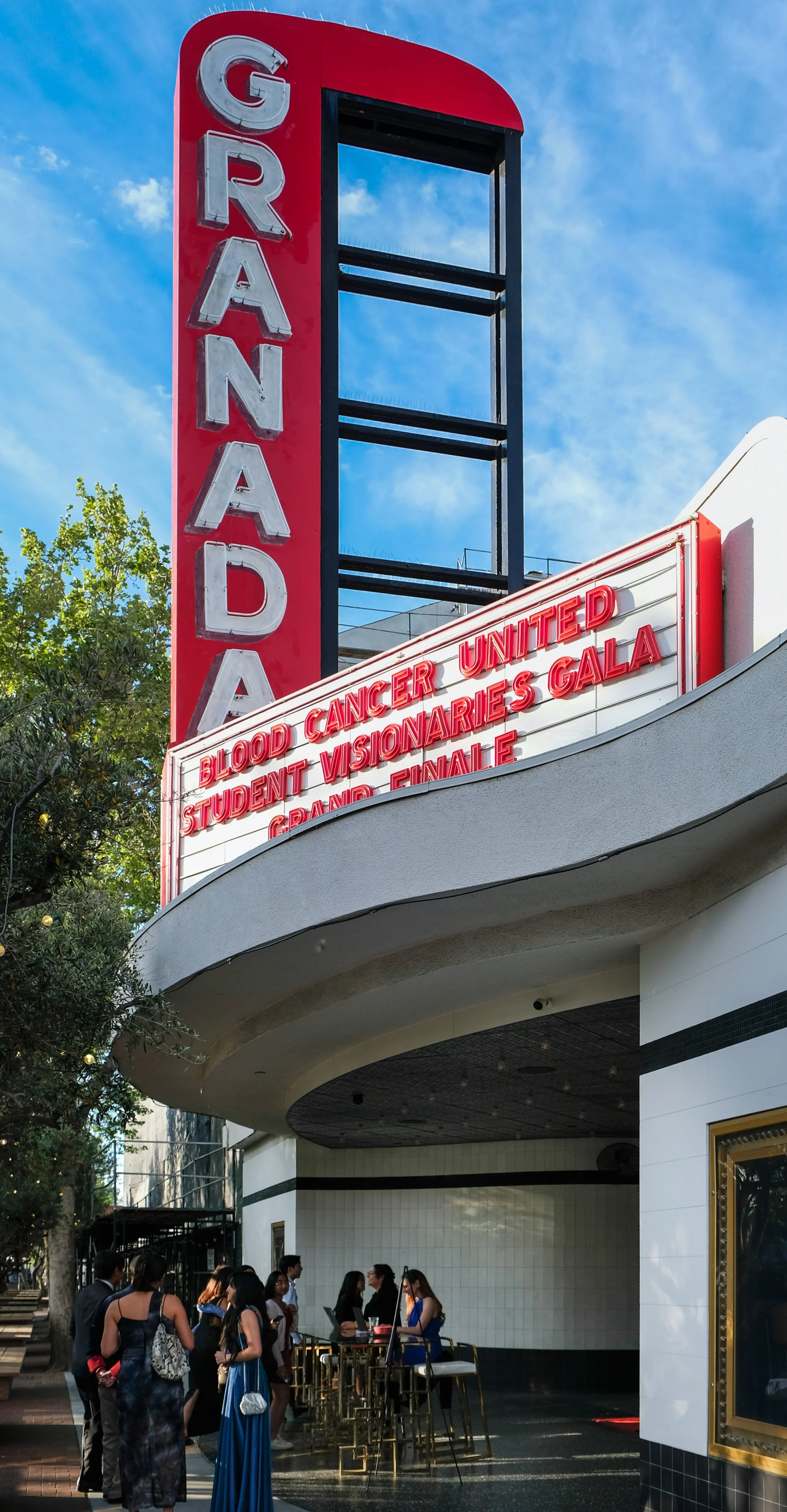 People waiting in line outside the Grauman's Chinese Theatre marquee, which is advertising the Blood Cancer United Gala event.