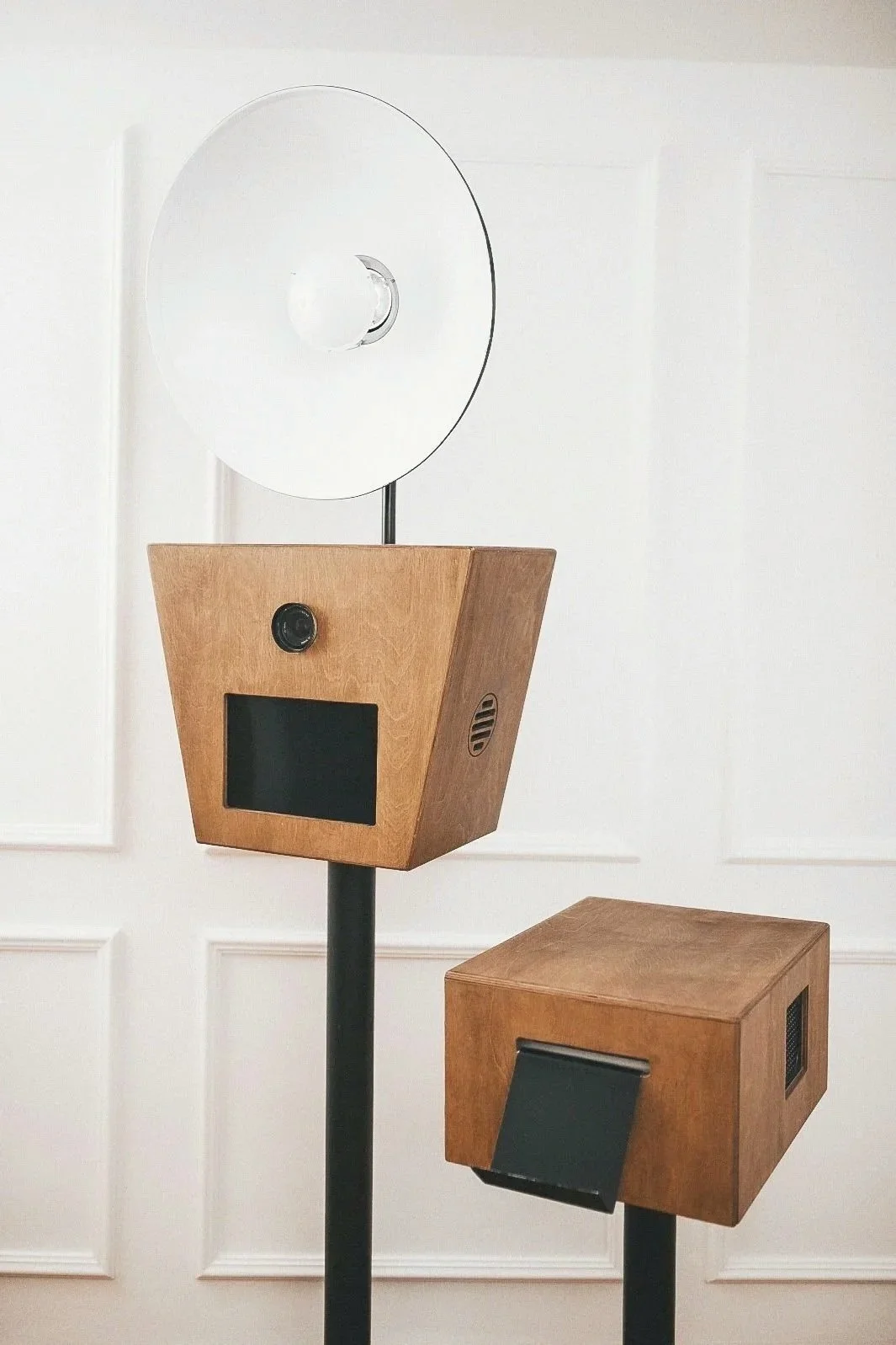 Ein modernes Kunstwerk, das aus Holzboxen und Spiegeln besteht, auf schwarzen Ständern montiert.