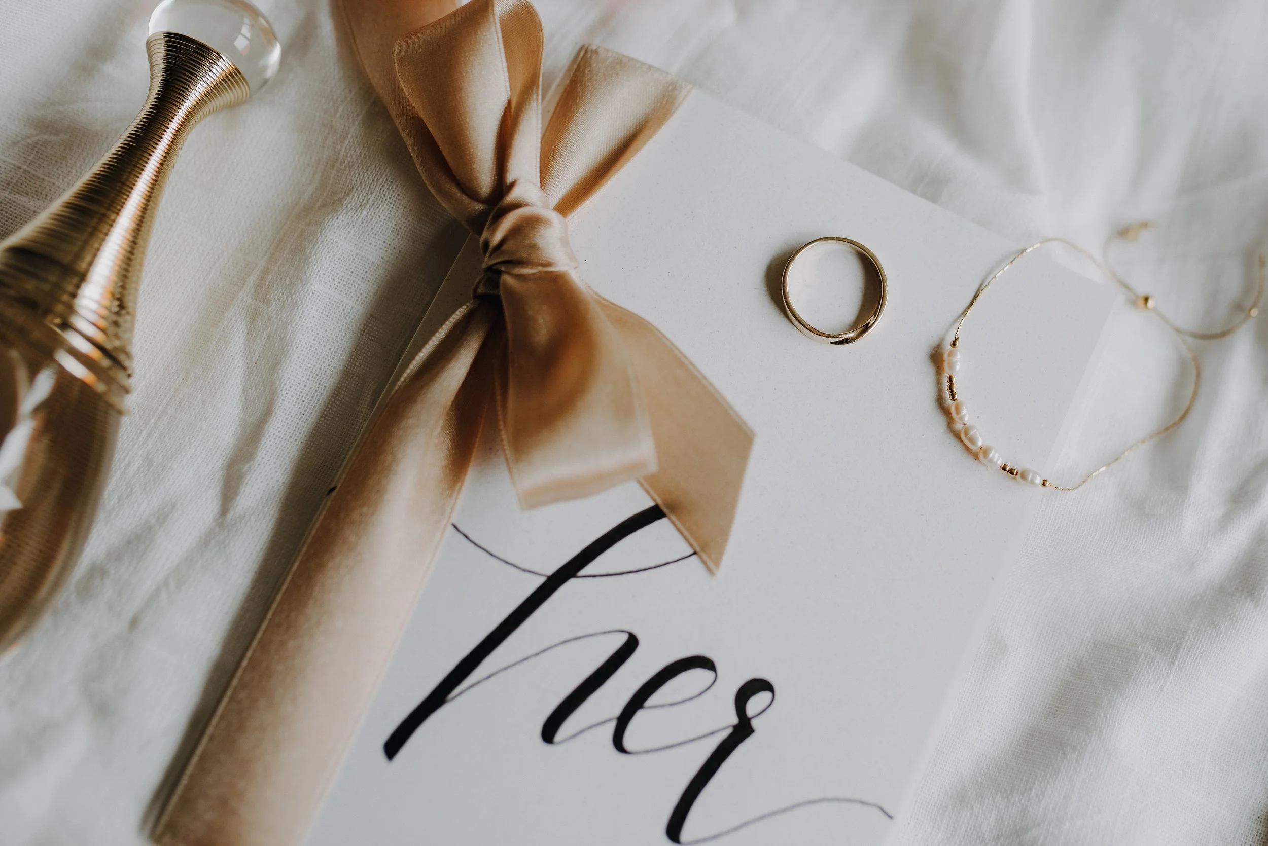 Verlobungsring, Ehering, Halskette und Romanze-Karte auf weißem Tuch