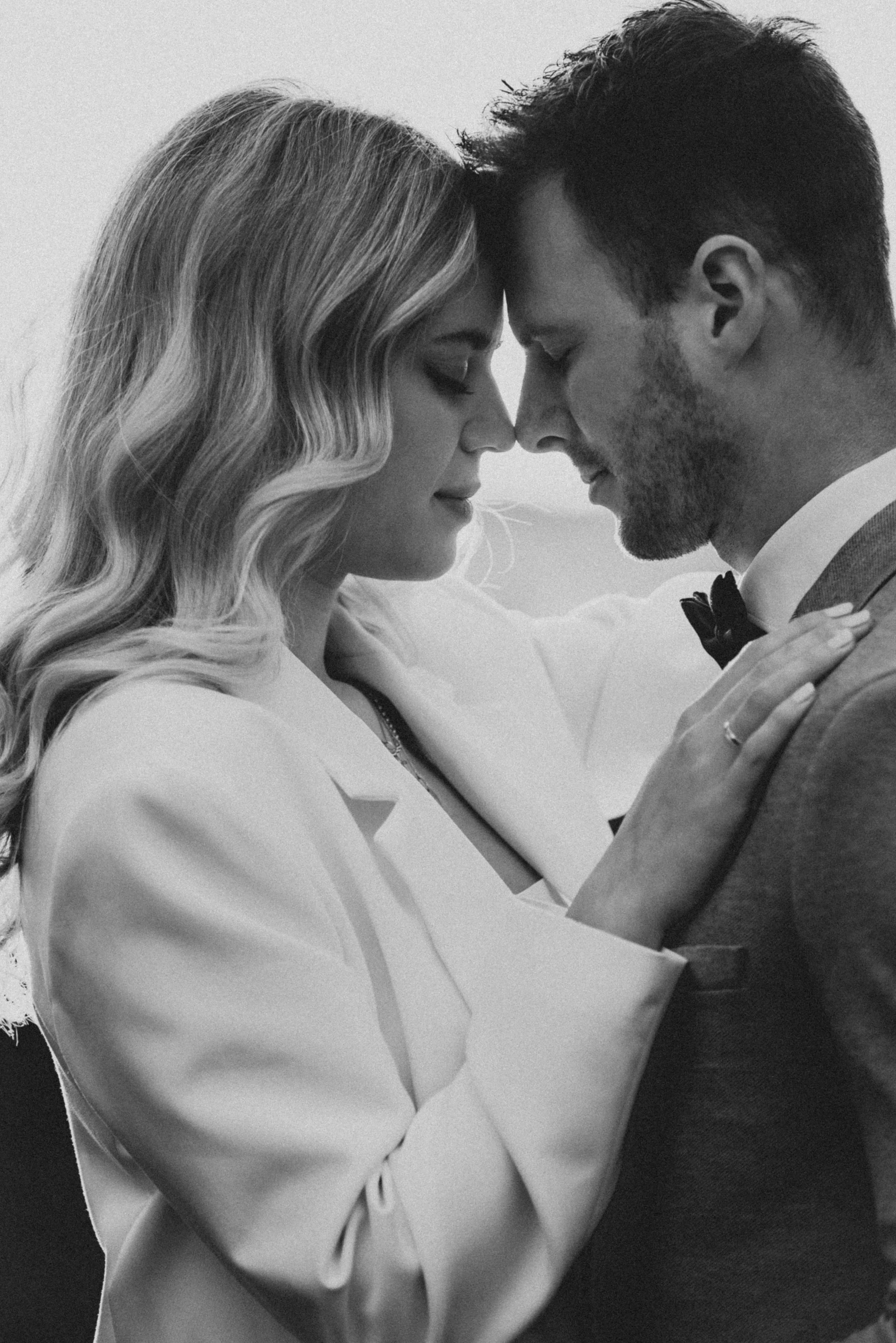 Ein schwarzer und weißer Himmel, eine Frau und ein Mann stehen sich nahe, die Stirnen berührend, mit geschlossenen Augen, zeigt eine zärtliche Umarmung und Intimität.