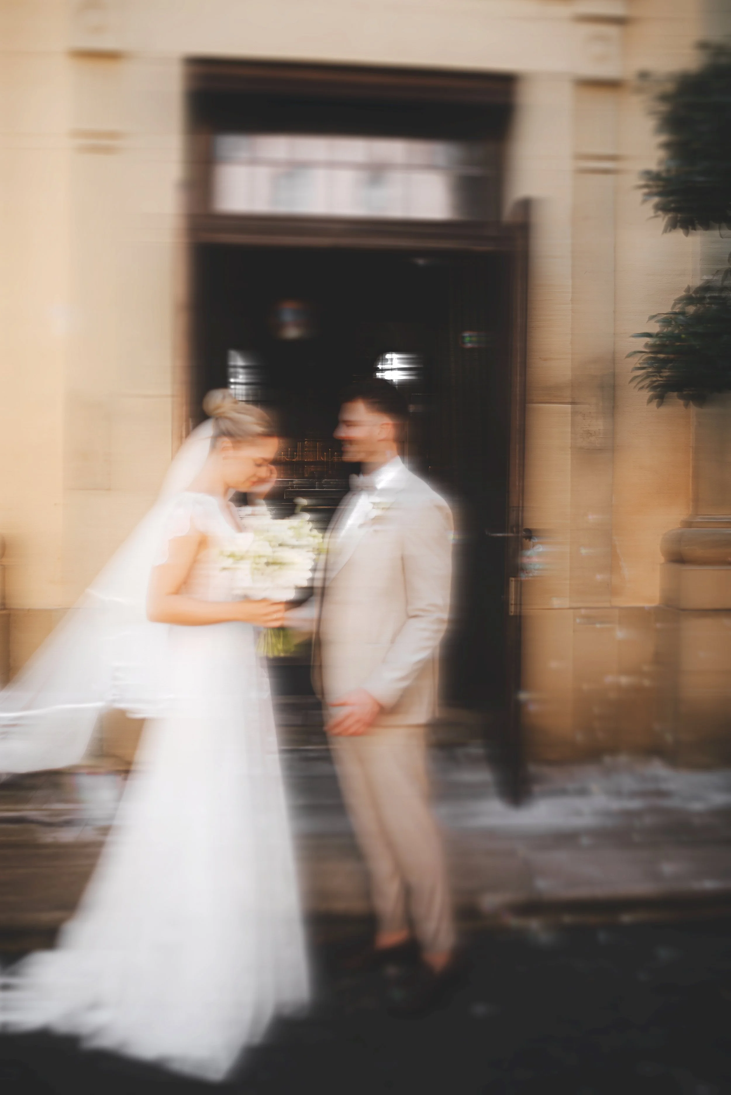 Verpixeltes Hochzeitsfoto eines Paares vor einem Gebäude bei Nacht, mit Bewegungseffekt.