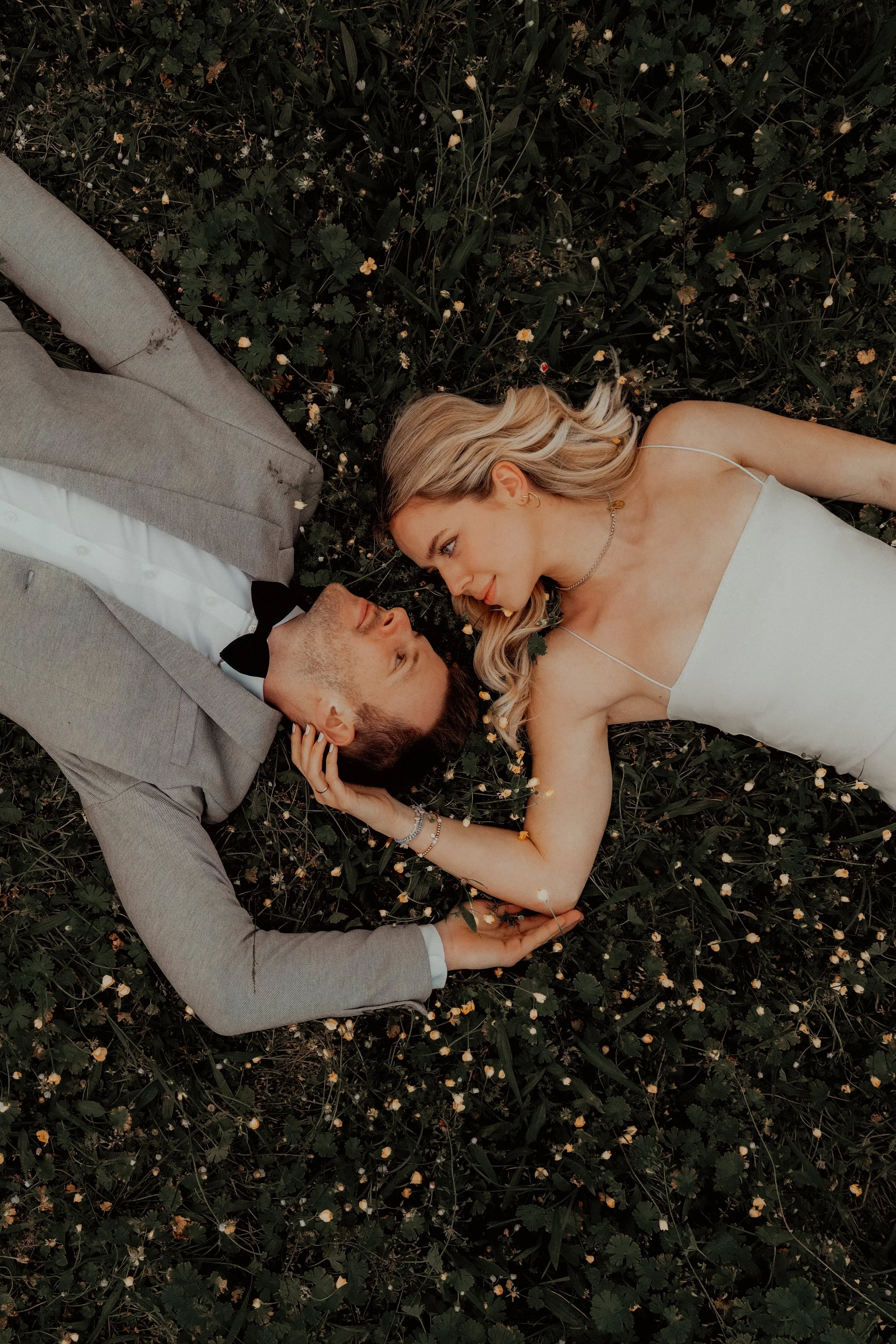 Paar liegt auf einer Wiese, Blickkontakt, verliebtes Moment, romantische Szene, Nahaufnahme