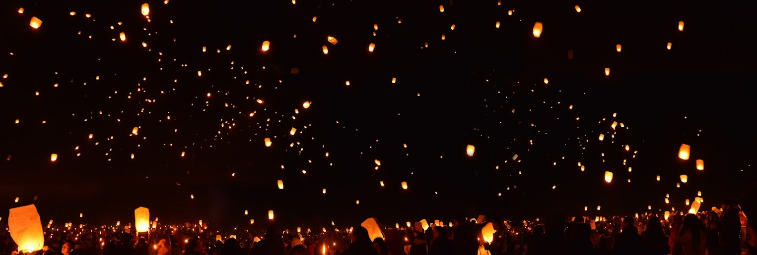 Paper lanterns floating into the night sky