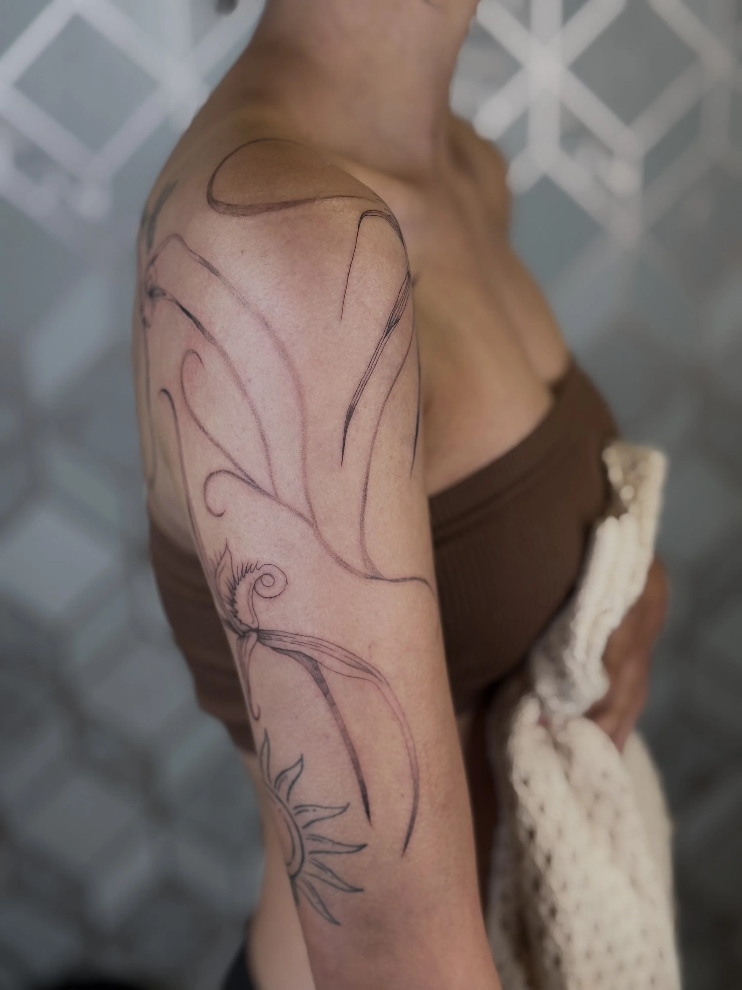 Fine line spider orchid linework tattoo flowing along the arm