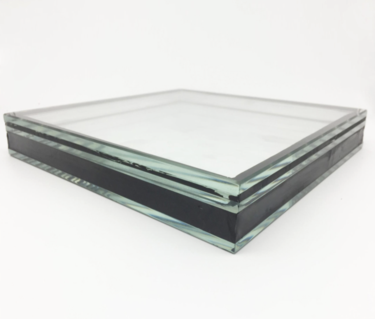 A clear glass block with black and transparent layers on a white background.