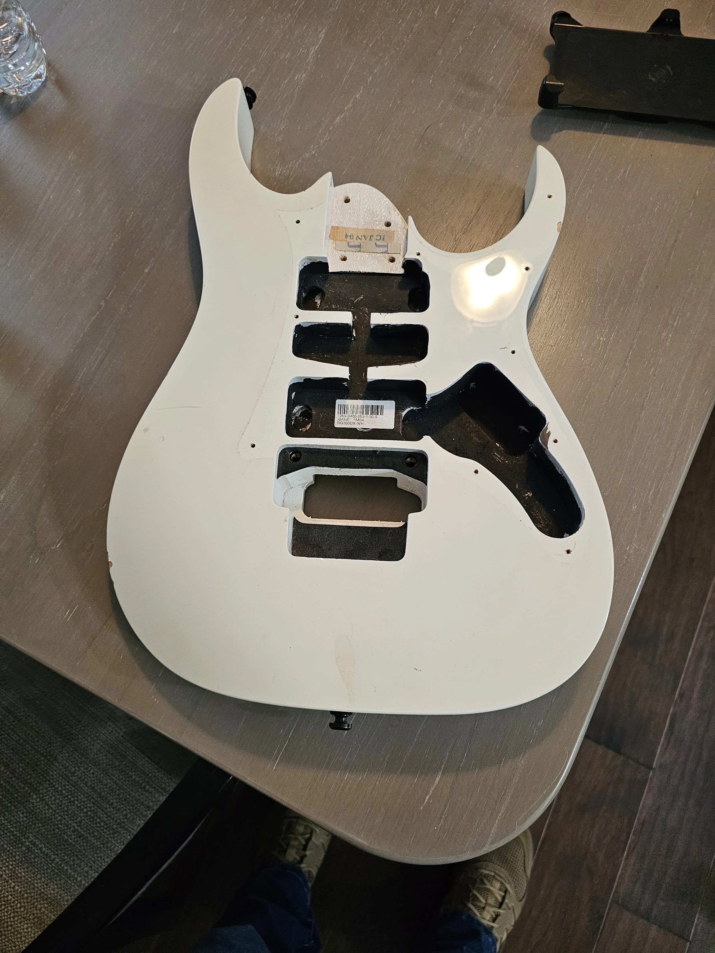 Disassembled electric guitar body with pickups and electronics cavity.