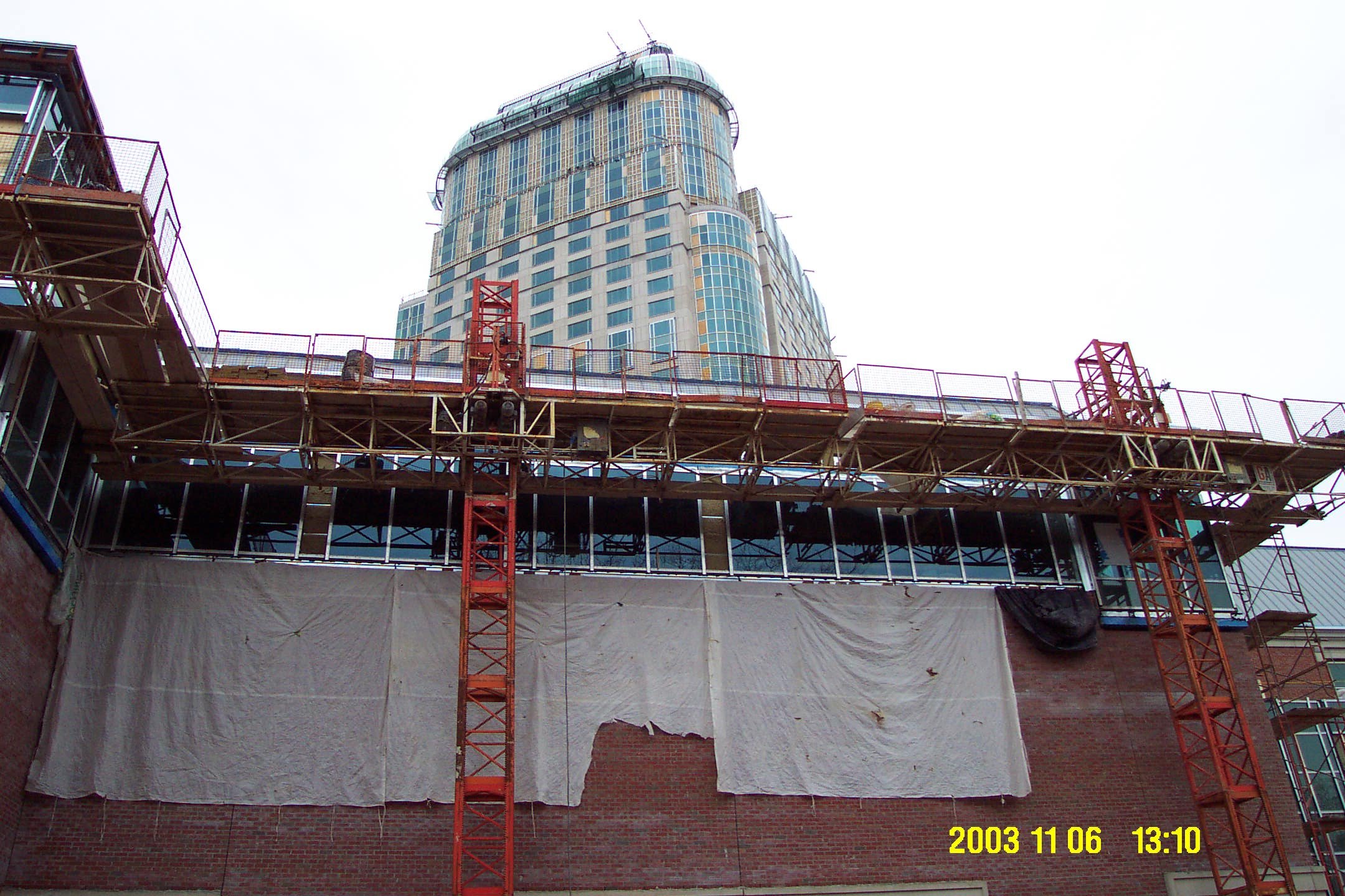 Construction site with scaffolding and a tall building under construction in an urban area.