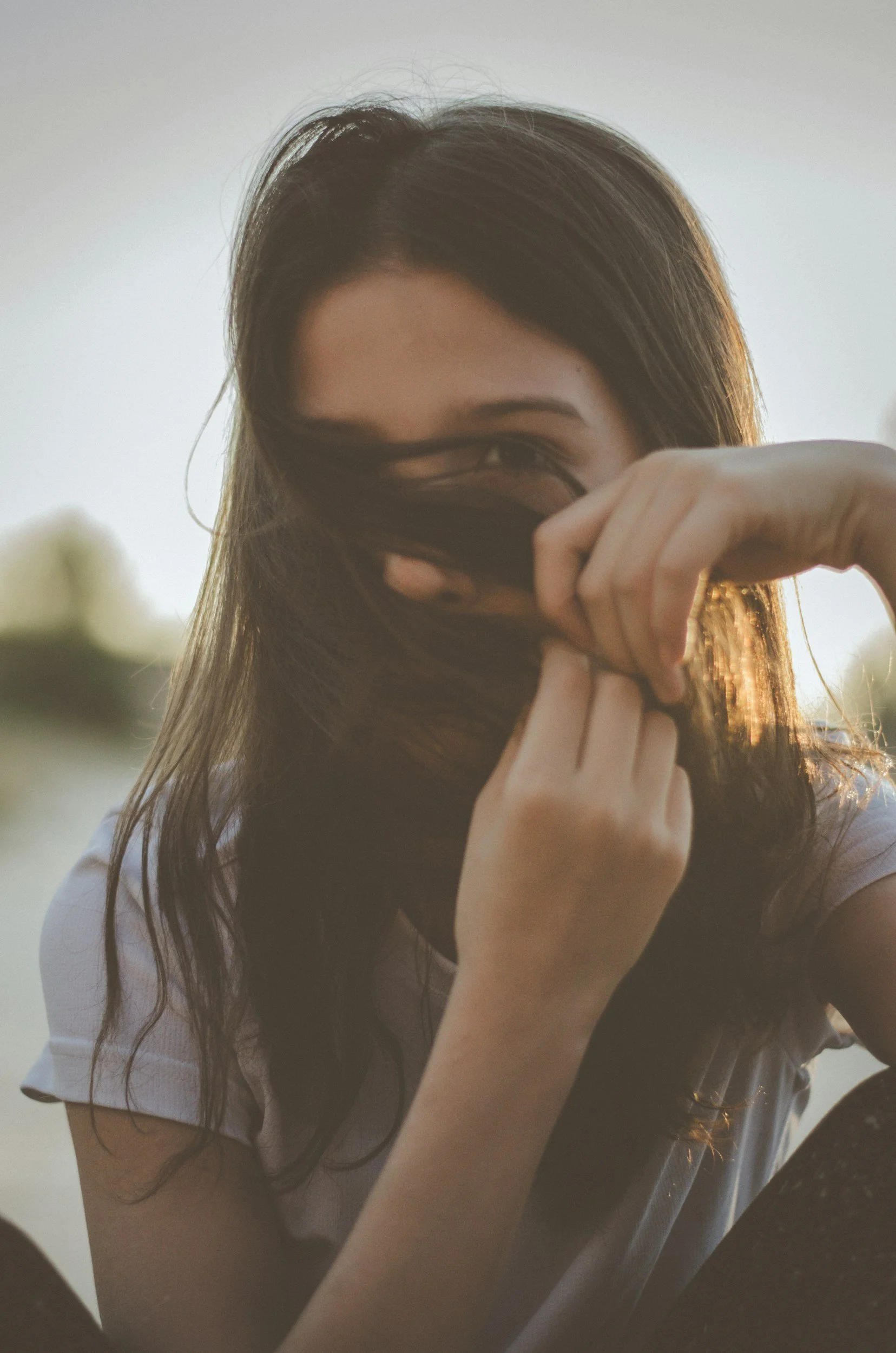 A young girl hiding her mouth because she is self-conscious about her stuttering in Jacksonville, FL.
