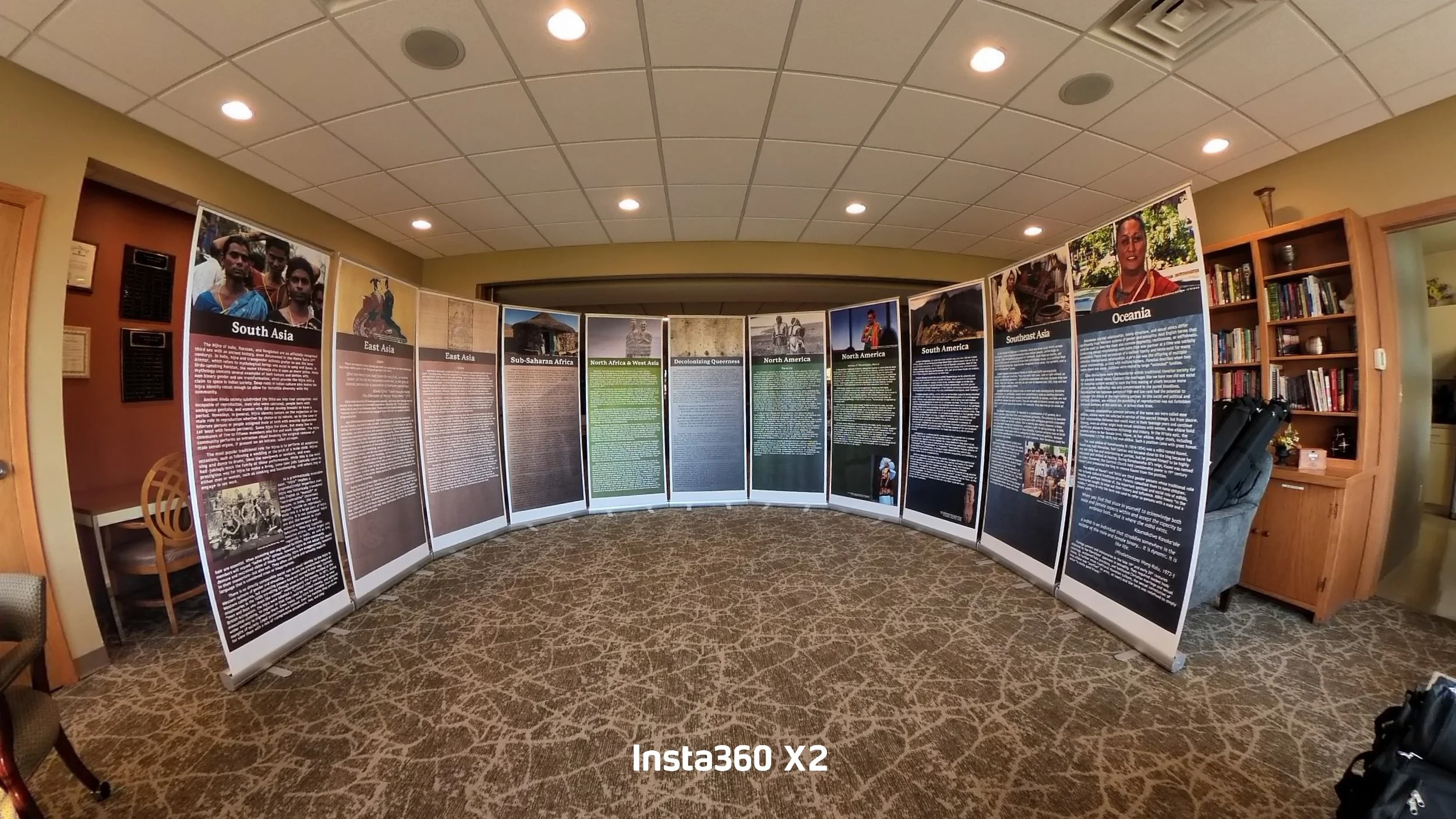 Indoor display of informational posters on cultural regions including South Asia, East Asia, Sub-Saharan Africa, North Africa & West Asia, North America, South America, Southeast Asia, and Oceania, with some photographs of people and landmarks.