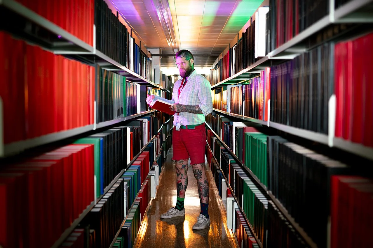 Reggie Grey staning in a University library in academia doing research